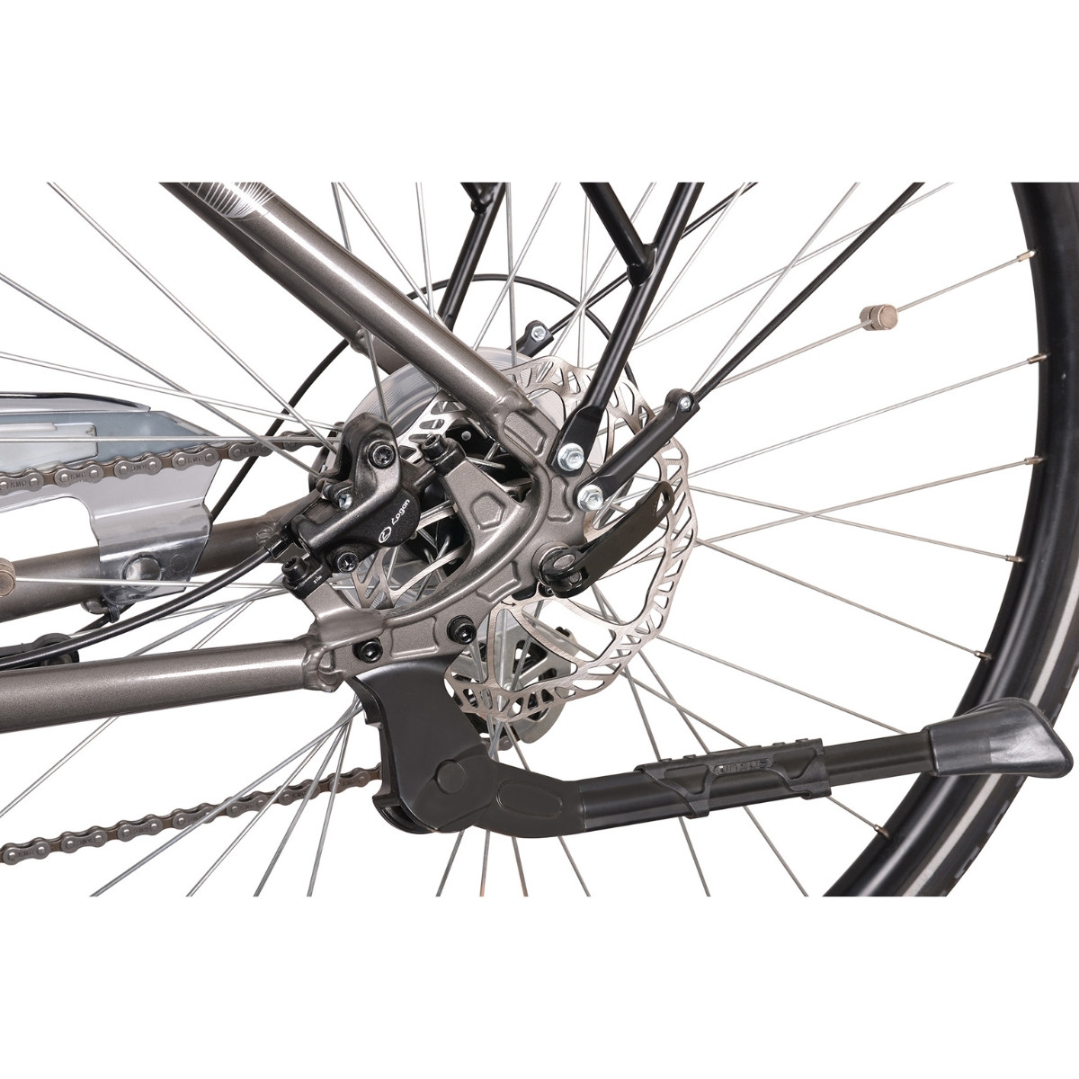 Zbliżenie tylnego koła roweru, pokazujące hamulec tarczowy, łańcuch i podpórkę.