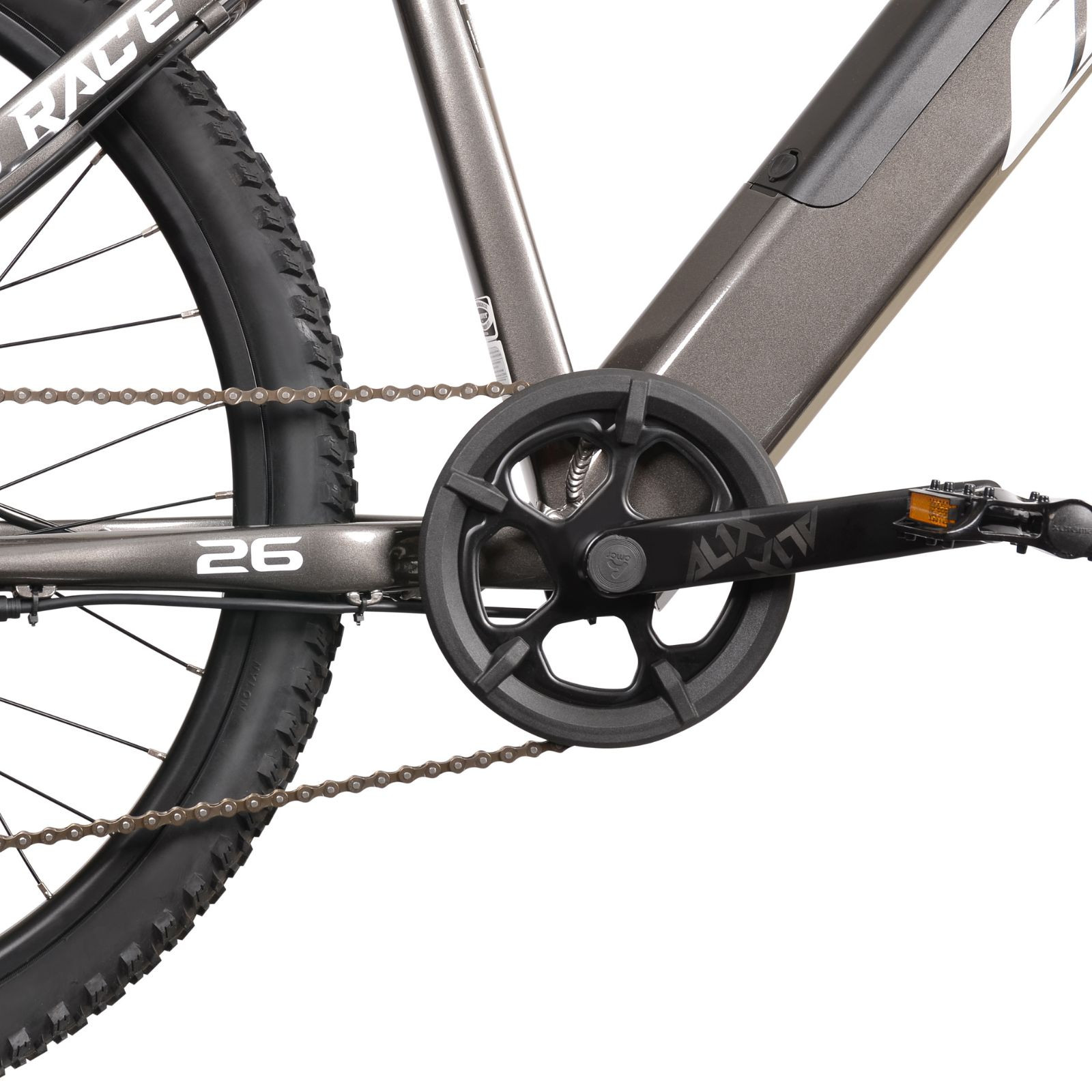 Zbliżenie na korbowód, łańcuch i tylne koło szarego roweru z oznaczeniem 26.