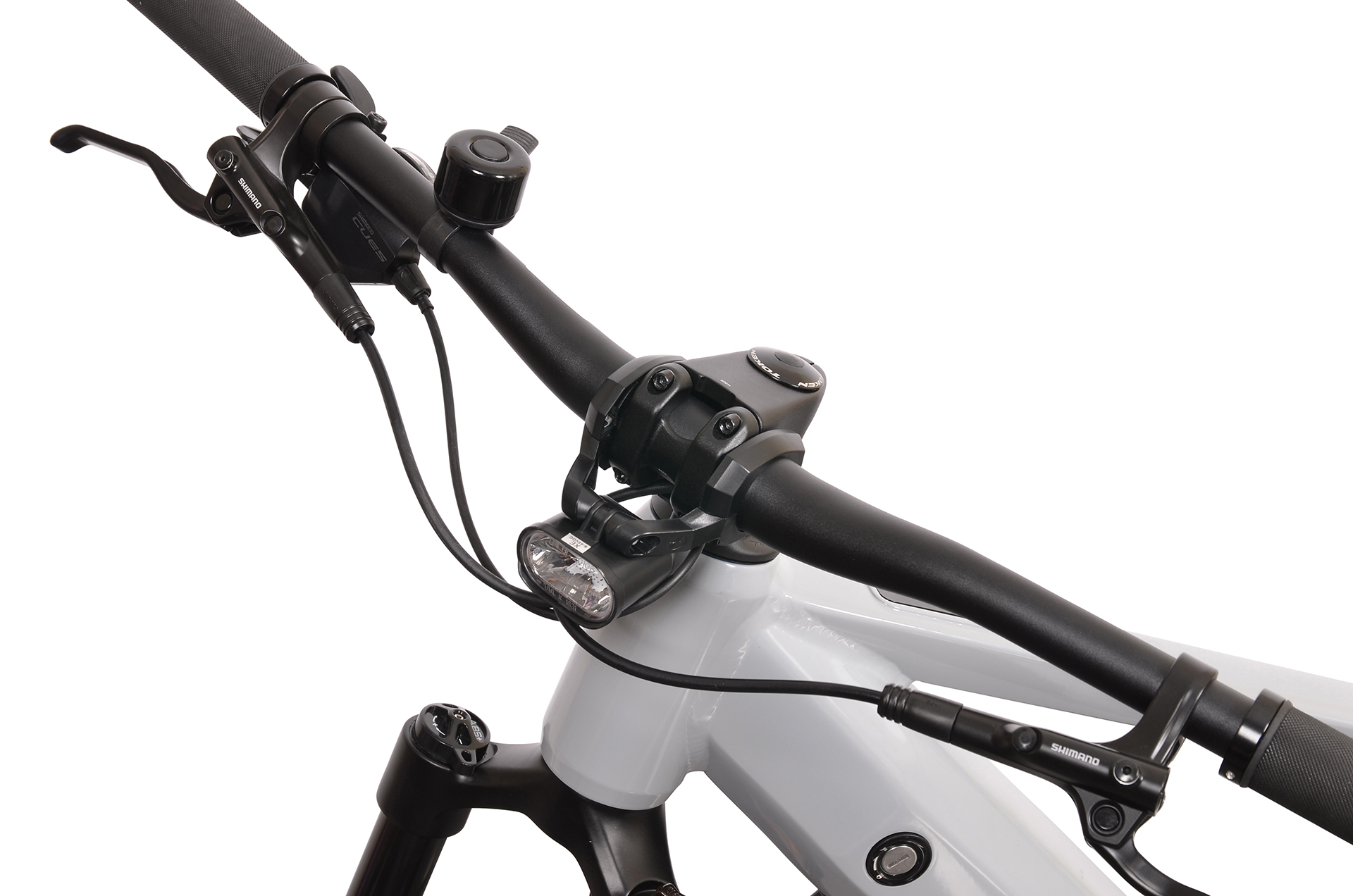 Zbliżenie na kierownicę szarego roweru z czarnymi chwytami, dźwigniami i dzwonkiem.