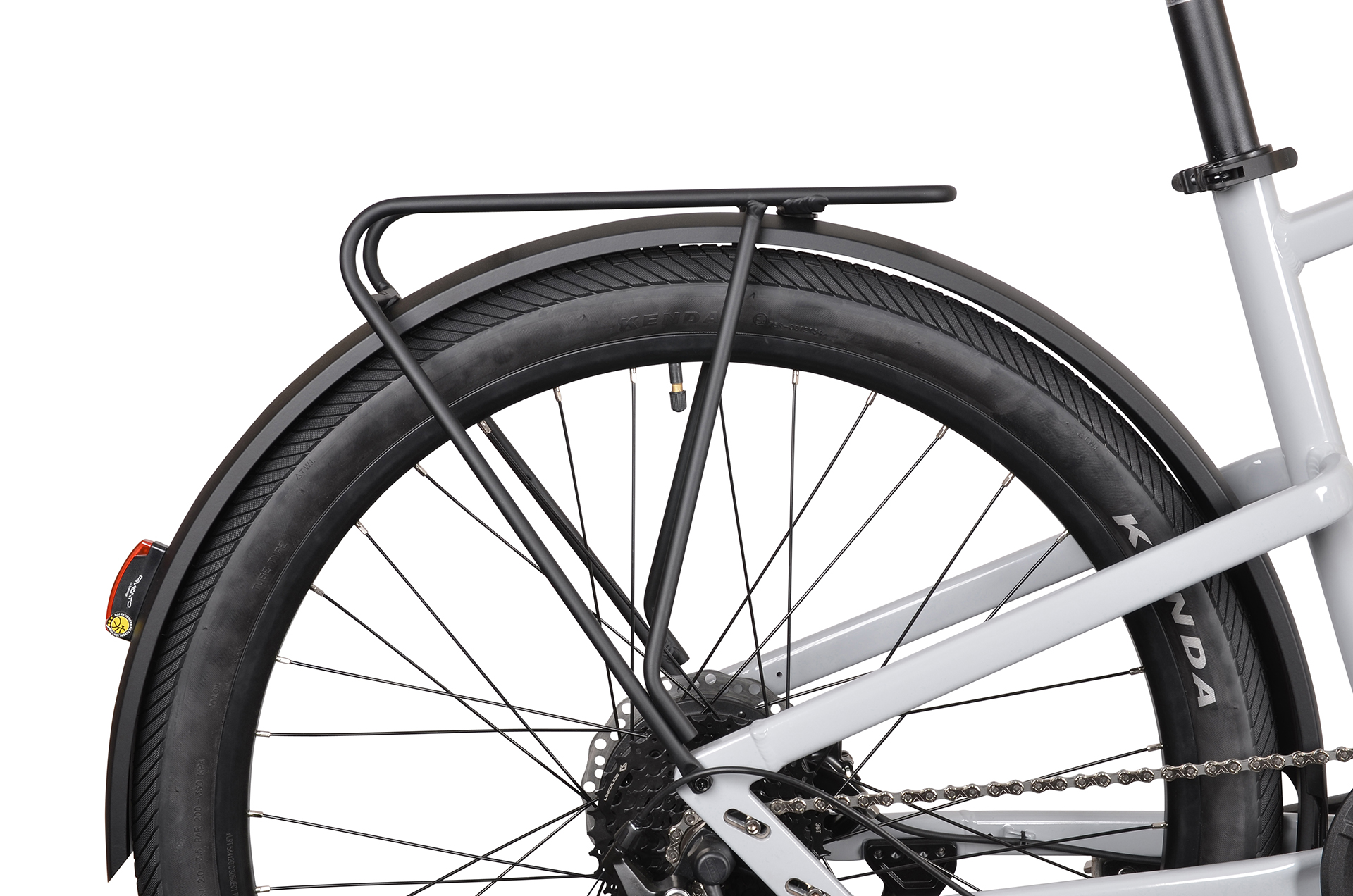 Zbliżenie tylnego koła szarego roweru z bagażnikiem i błotnikiem.