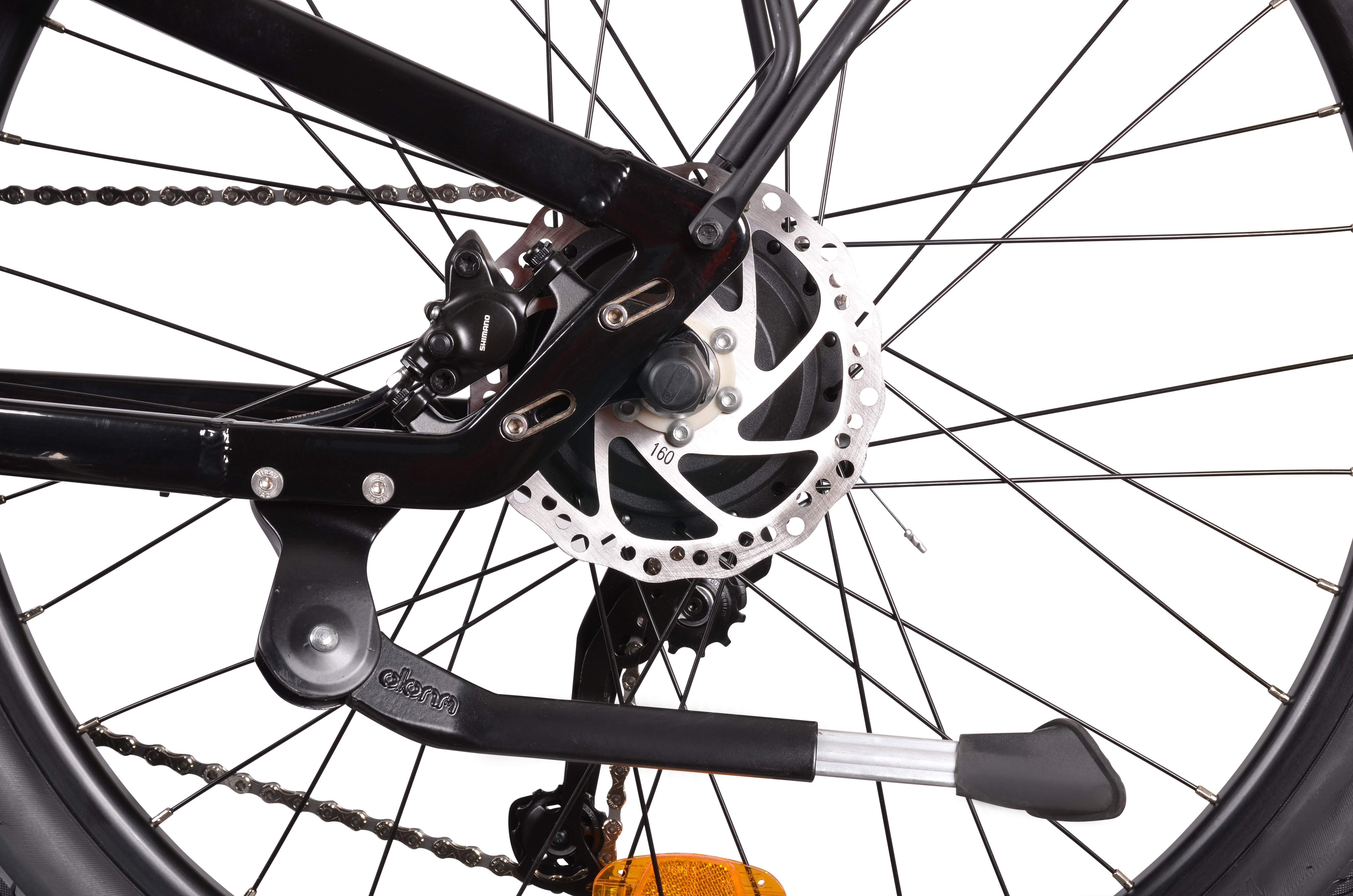 Zbliżenie tylnego koła czarnego roweru, pokazujące łańcuch, hamulec tarczowy i podpórkę.