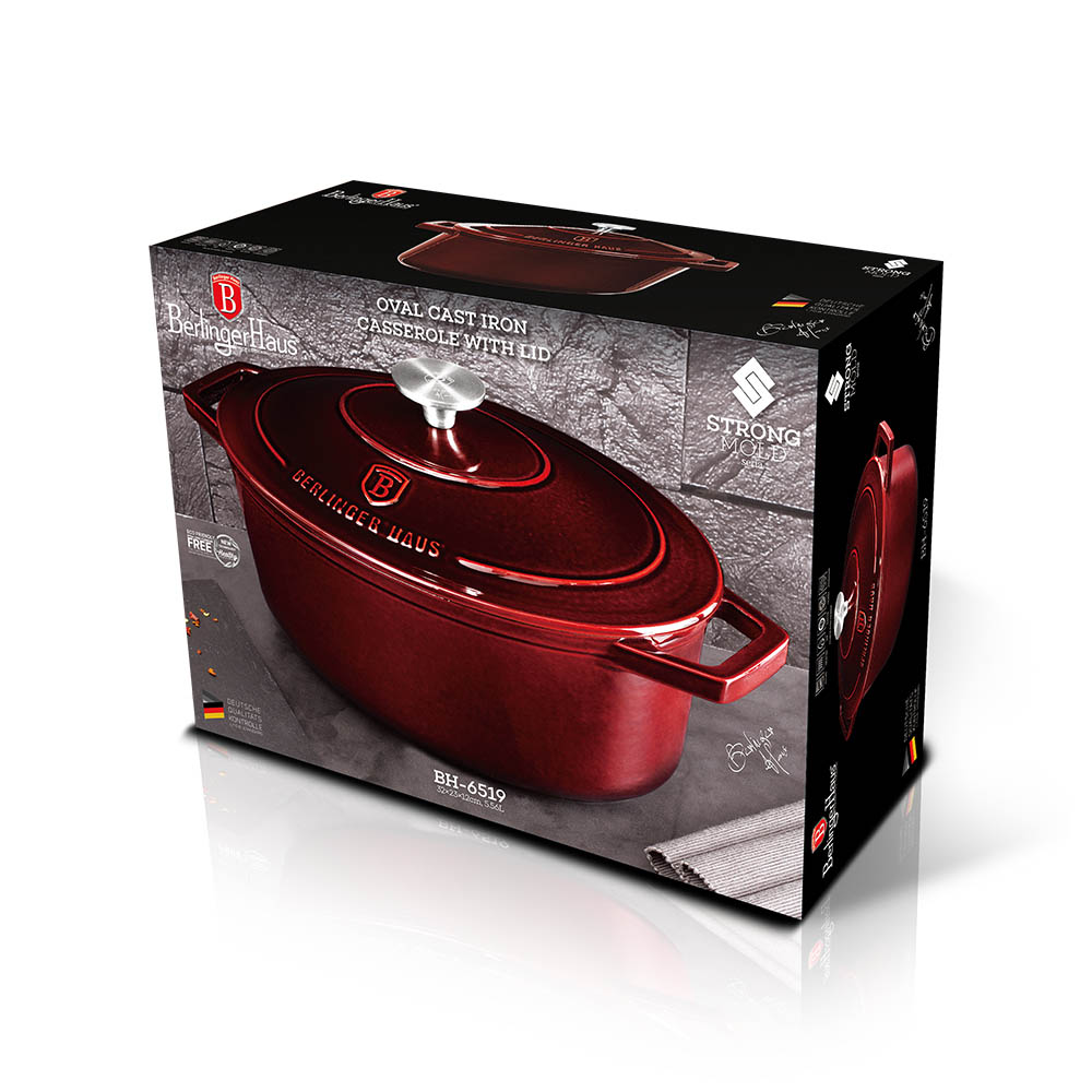 Ovaler gusseiserner Bräter mit Deckel in Rot, auf Kartonverpackung.