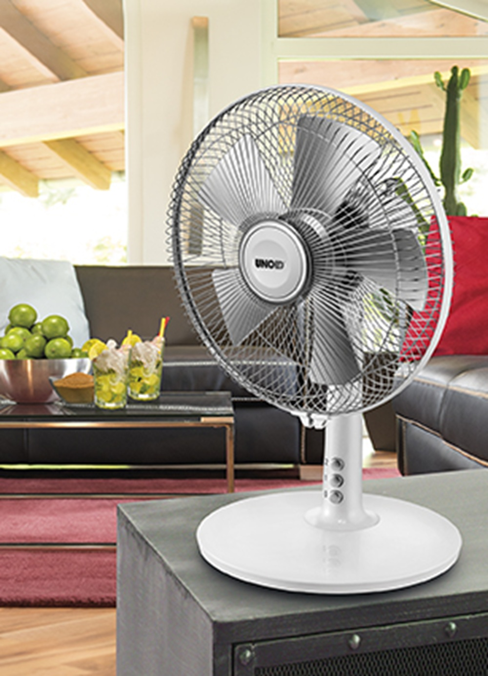 Biało-srebrny wentylator elektryczny z logo "UNOLD", umieszczony na ciemnoszarej powierzchni w salonie.