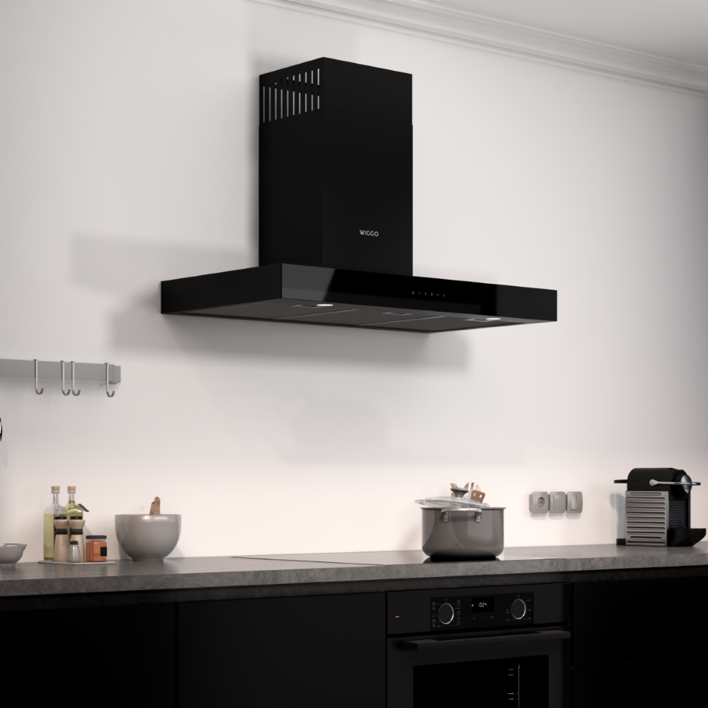 Zwarte afzuigkap boven een inductiekookplaat met pan en koffiezetapparaat.