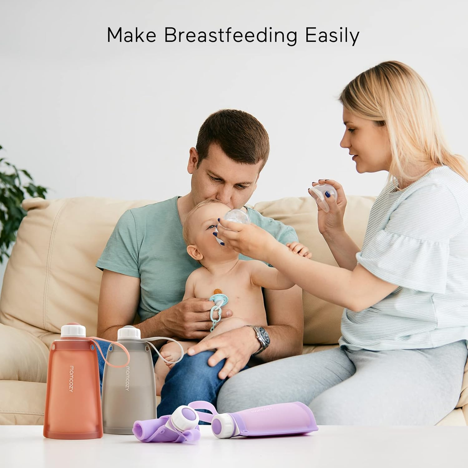 Familie mit Baby auf Sofa, Flaschen und Becher auf Tisch.
