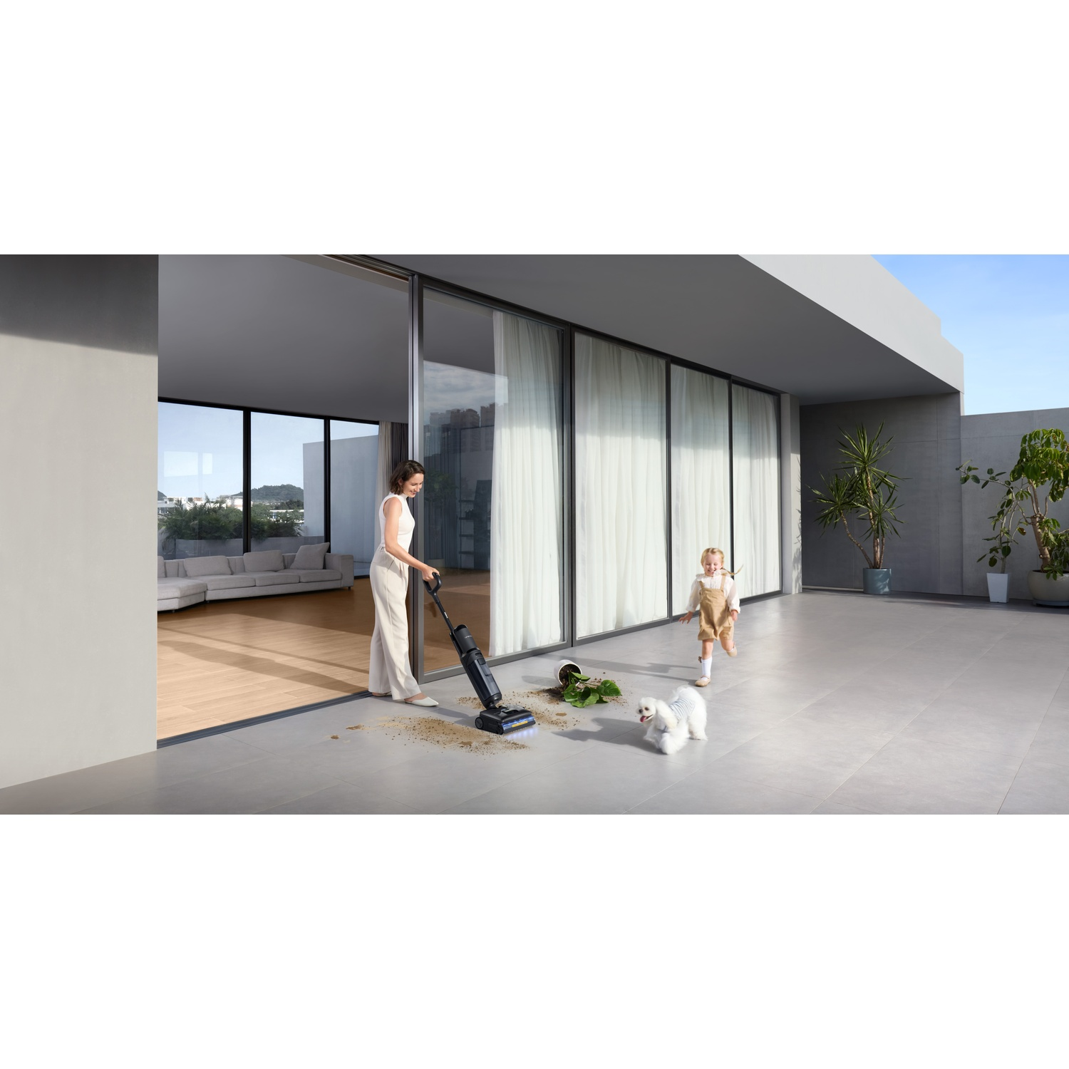 Kobieta odkurza na tarasie, podczas gdy dziecko i pies bawią się obok.