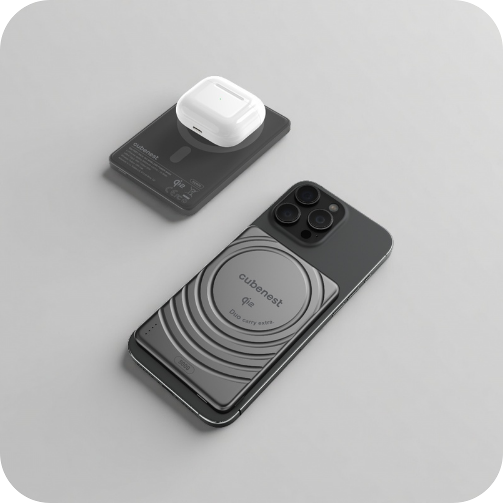 Ein schwarzes iPhone mit grauem MagSafe-Akku und weißen AirPods-Hülle daneben.