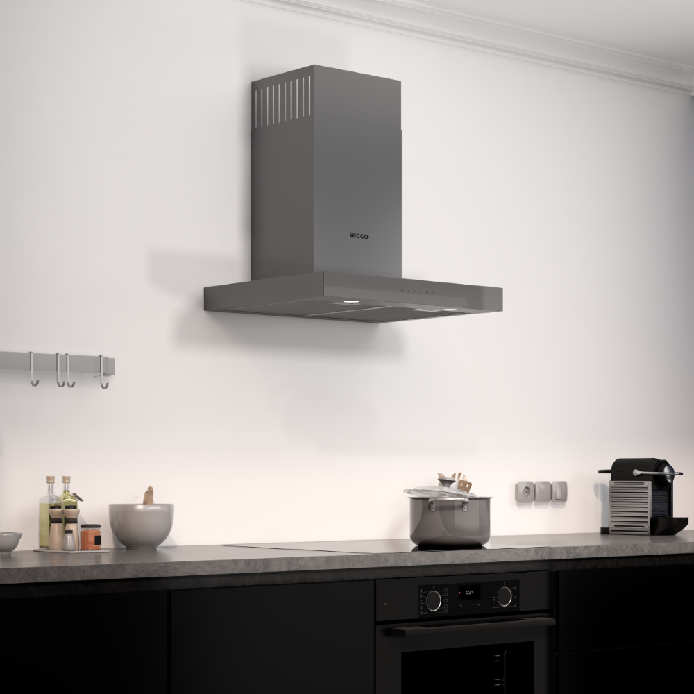 Hotte grise au-dessus de la plaque de cuisson avec casserole, cafetière et armoires.