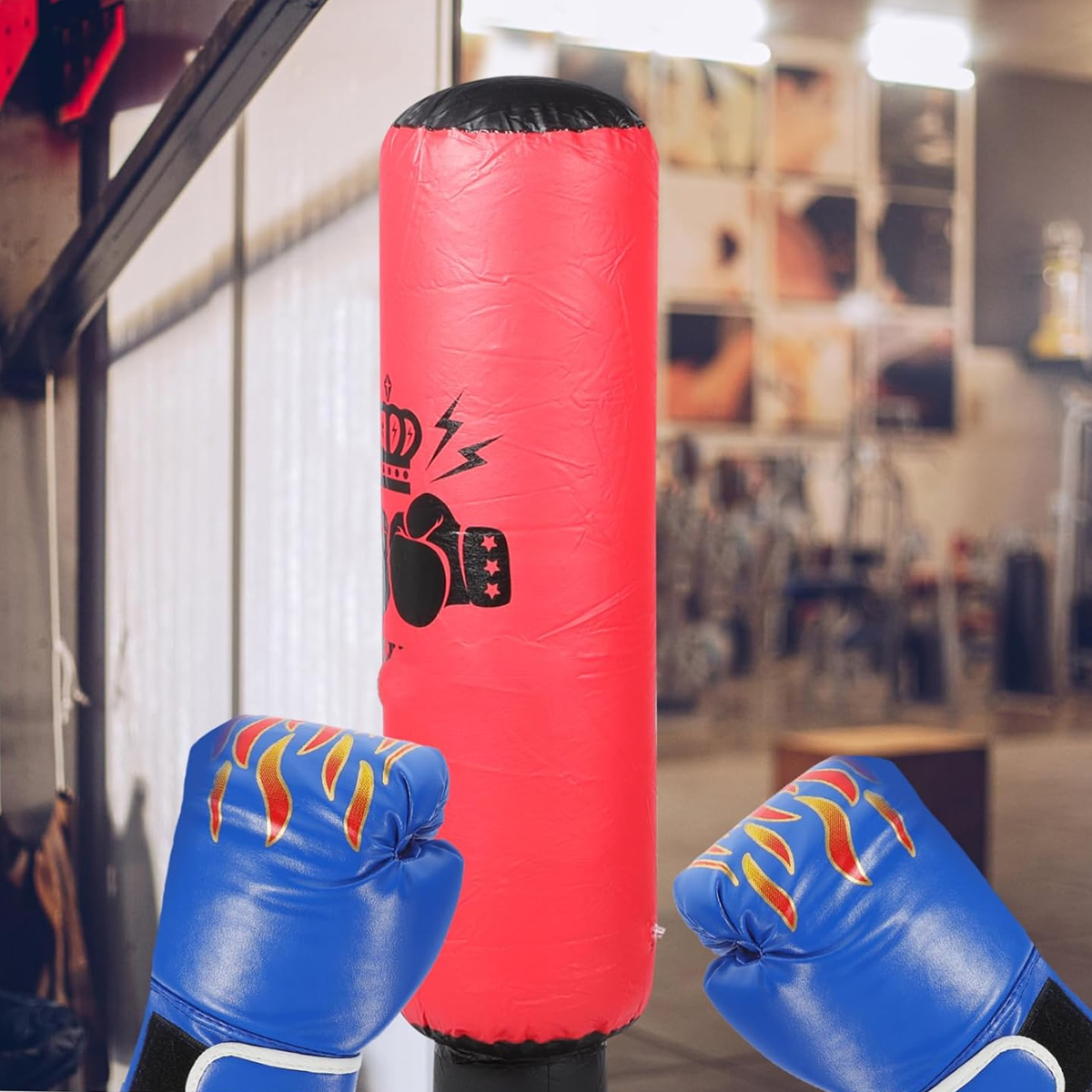 Ein roter Boxsack mit blauen Handschuhen davor in einem Fitnessstudio.
