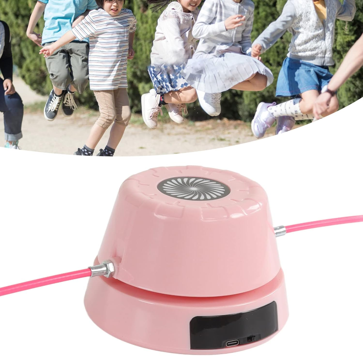 Kinder springen Seil; ein rosa Springseilgerät ist im Vordergrund.