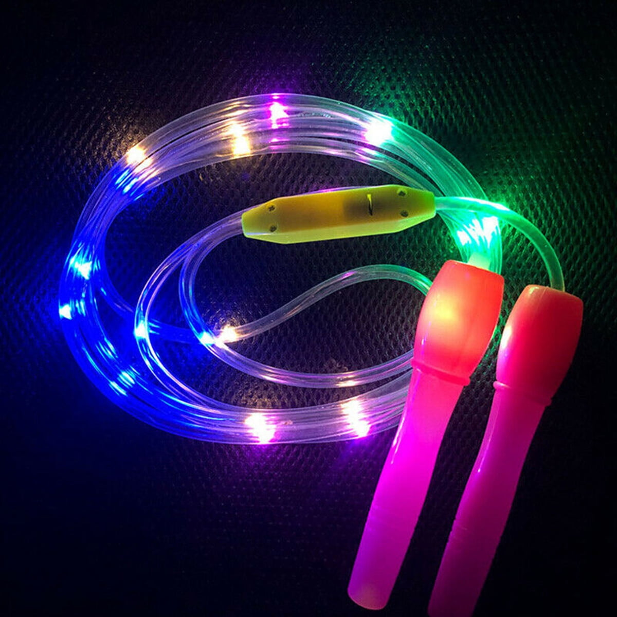 Ein durchsichtiges Springseil mit bunten LEDs und pinken Griffen auf dunklem Hintergrund.