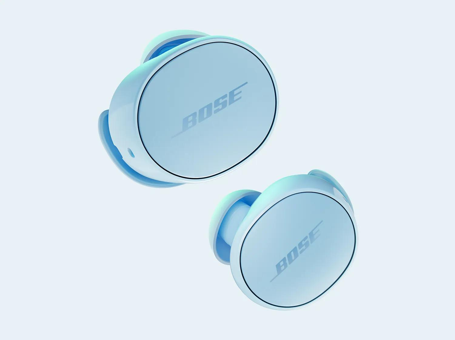 Due auricolari Bose azzurri con il logo Bose sono angolati su uno sfondo azzurro.