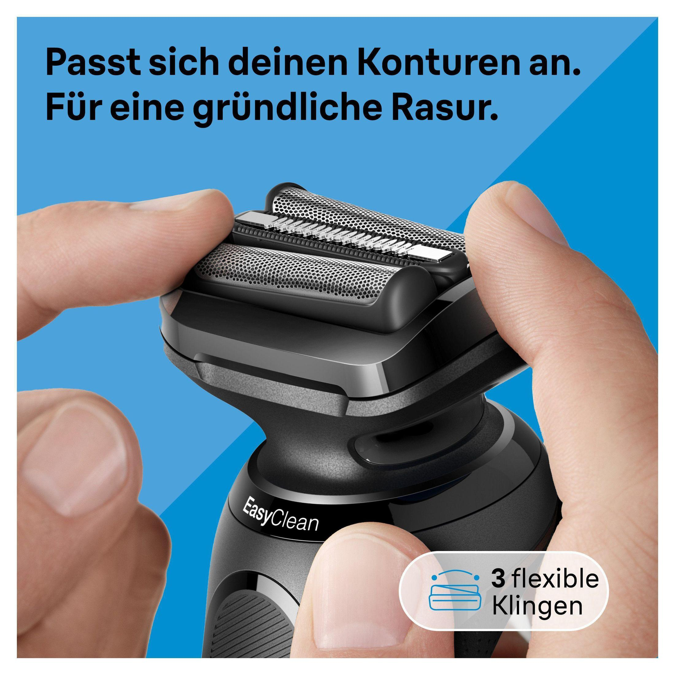Ein Mann hält einen schwarzen Elektrorasierer mit drei flexiblen Klingen.