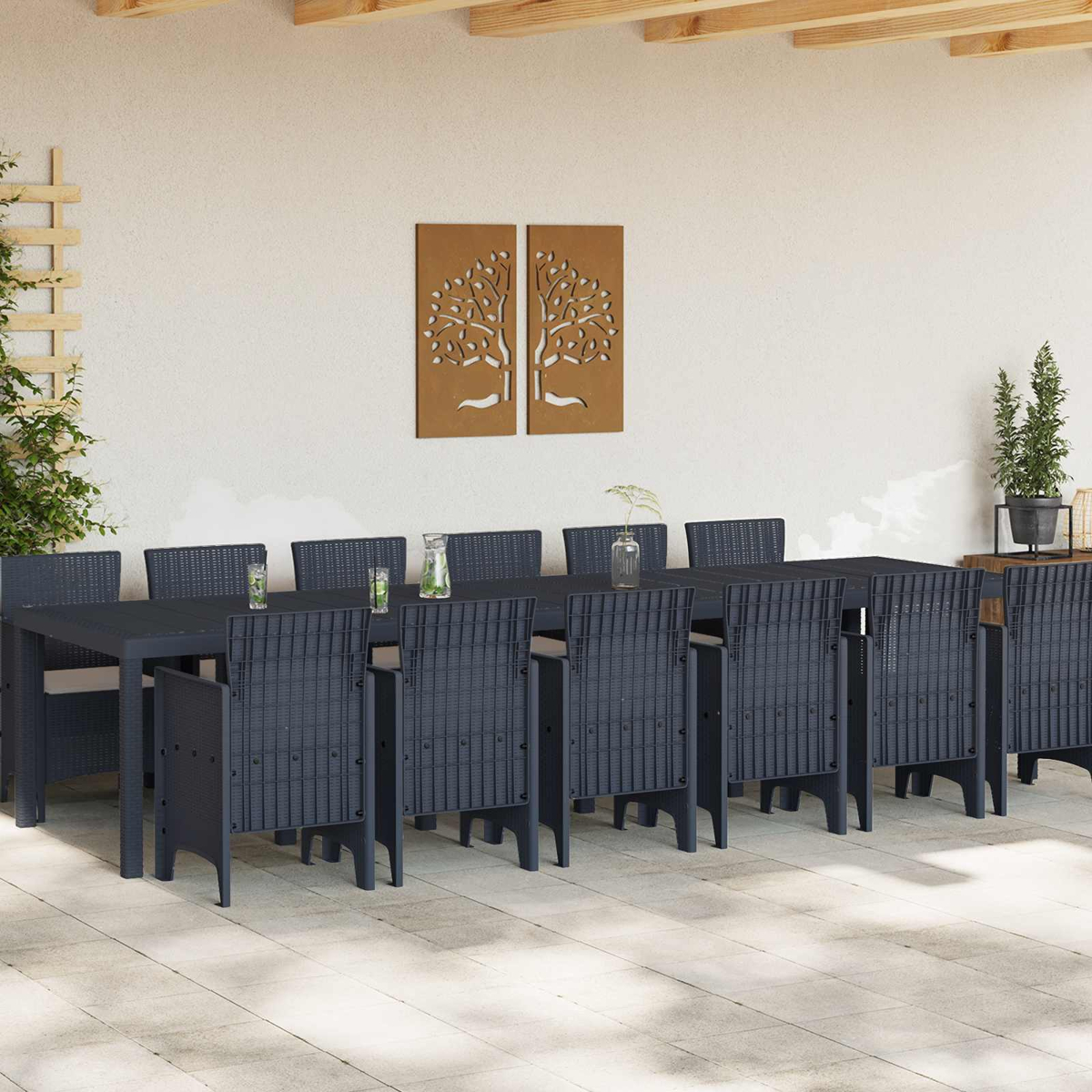 Dunkelgraue Rattansessel und Tisch auf einer hellen Terrasse, mit Wandkunst.