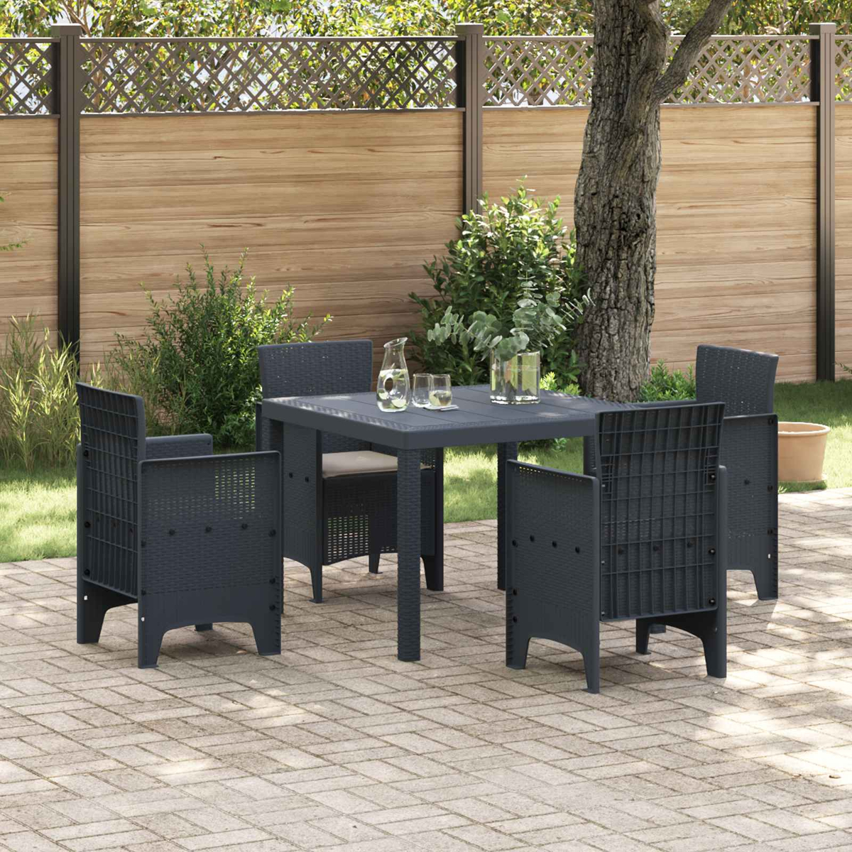 Ein dunkler Gartentisch mit vier Stühlen steht auf einer gepflasterten Terrasse.