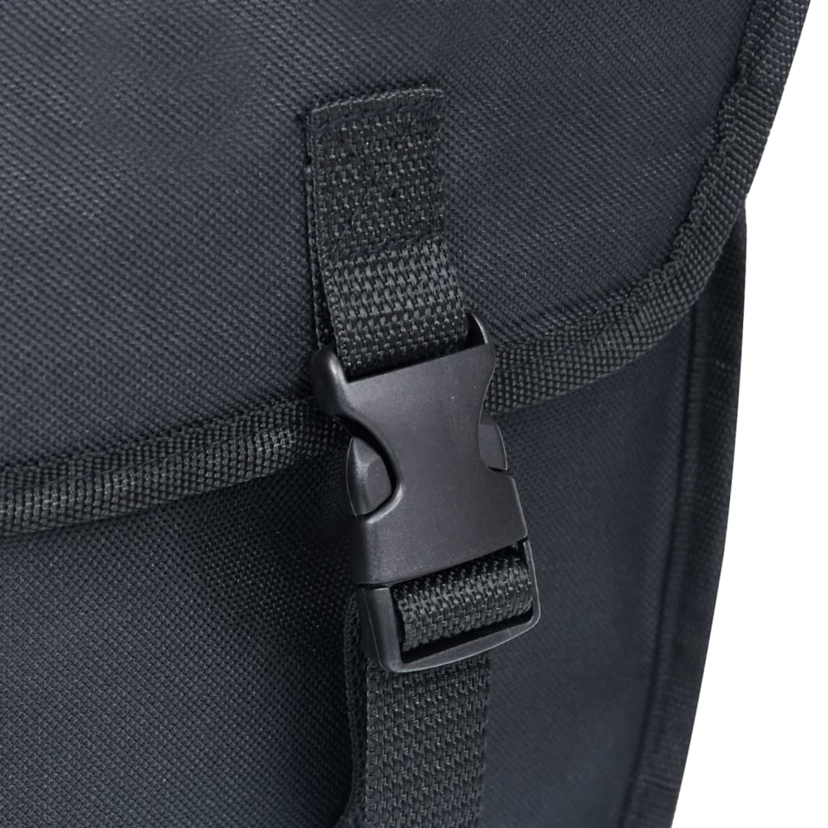 Schwarzer Klickverschluss an einem schwarzen Stoffriemen, befestigt an einer Tasche.
