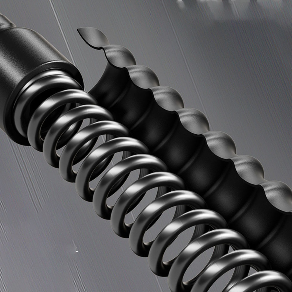 Zbliżenie czarnej sprężyny śrubowej obok elementu przypominającego śrubę.
