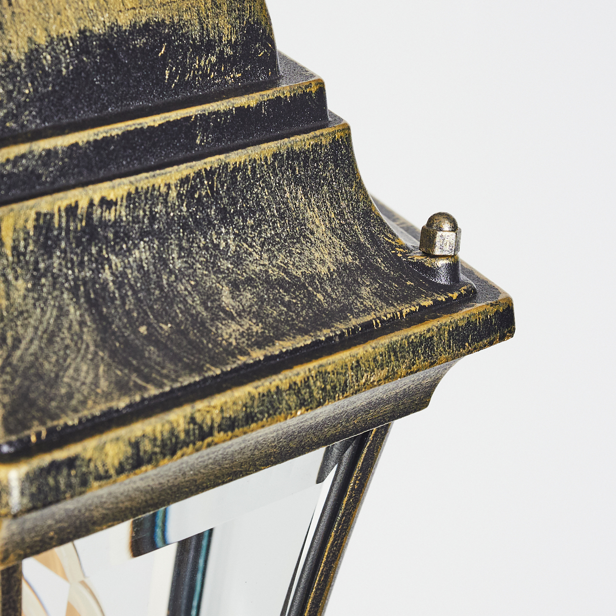 Detailaufnahme einer schwarz-goldenen Laterne mit einem scharfen, geometrischen Dach.