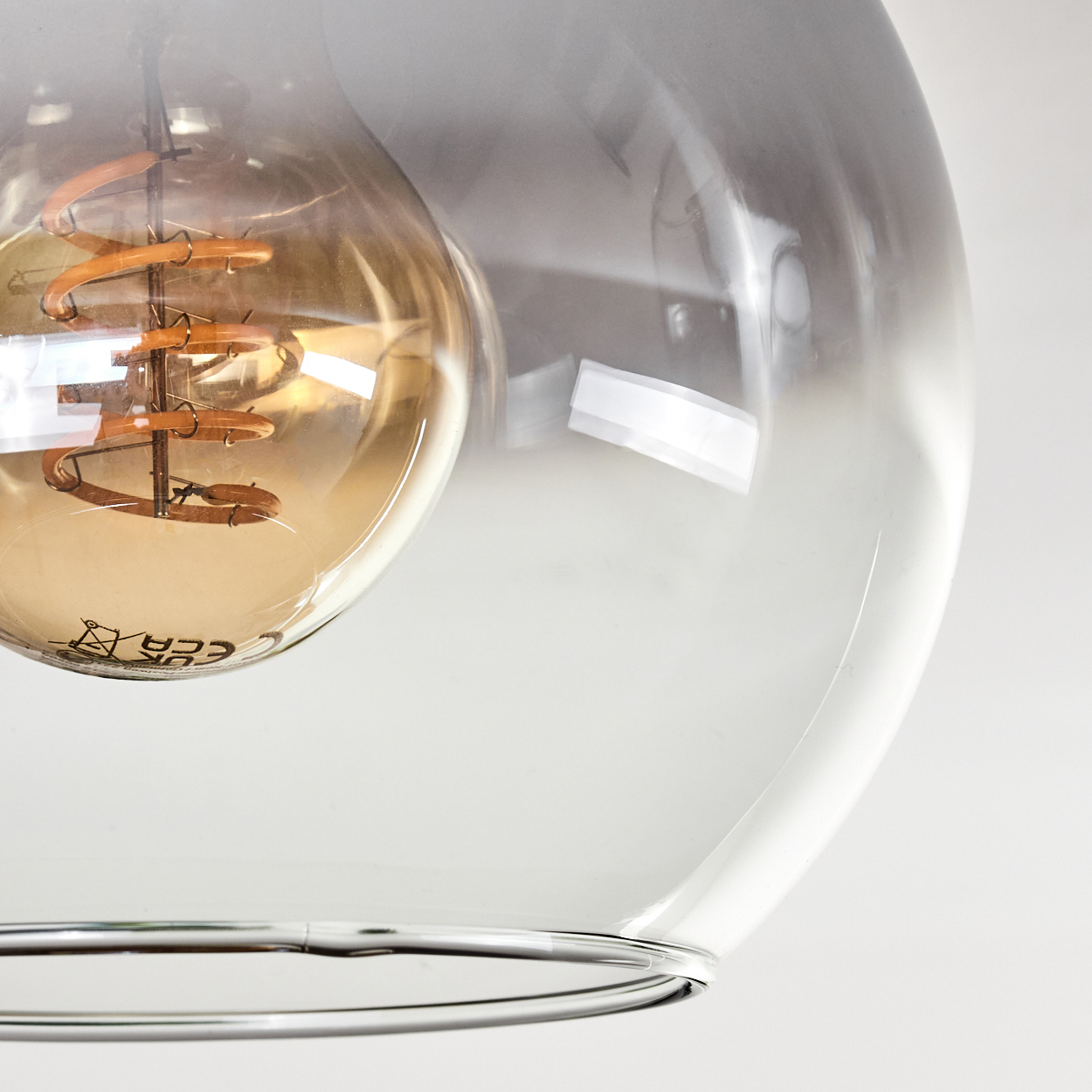 Nahaufnahme einer Vintage-Edison-Glühbirne in einer klaren Glaskugel.
