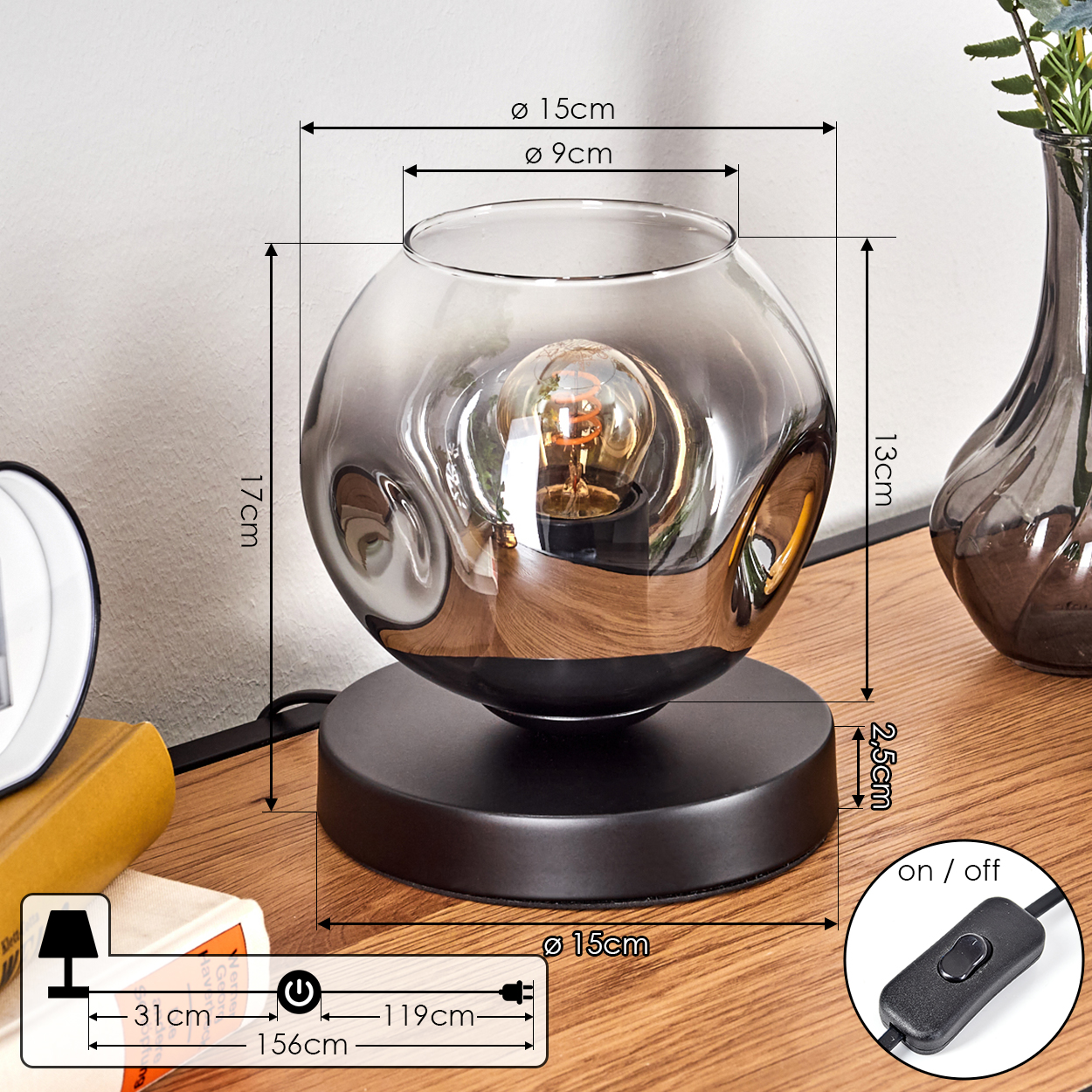 Eine kugelförmige Rauchglas-Lampe mit Glühbirne auf einem schwarzen Sockel.
