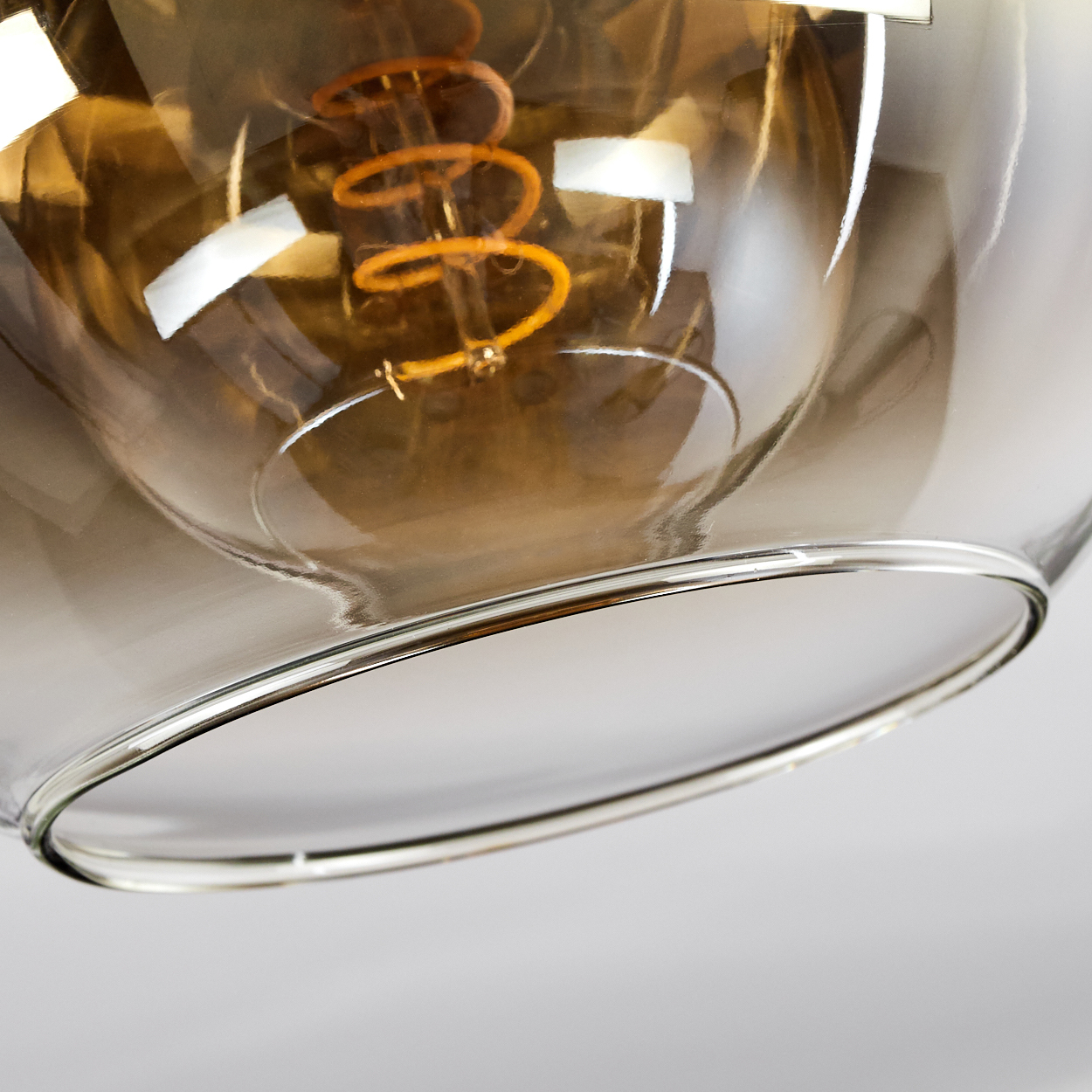 Eine Nahaufnahme einer Glühbirne mit einem spiralförmigen Glühfaden in einem Glasgehäuse.