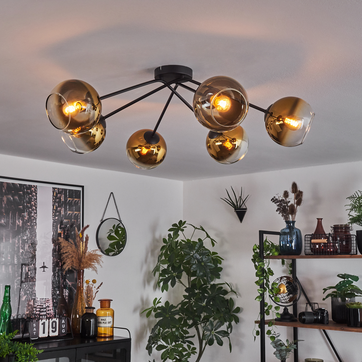 Moderne Deckenleuchte mit goldenen Glaskugeln und schwarzen Metallarmen.