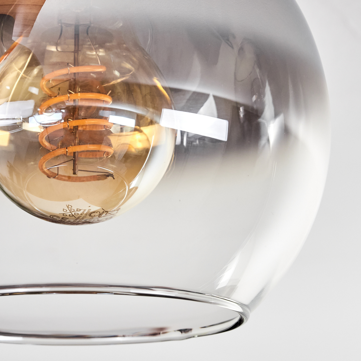 Eine Nahaufnahme einer Edison-Glühbirne mit Spiralwendel in einem transparenten Glaslampenschirm.