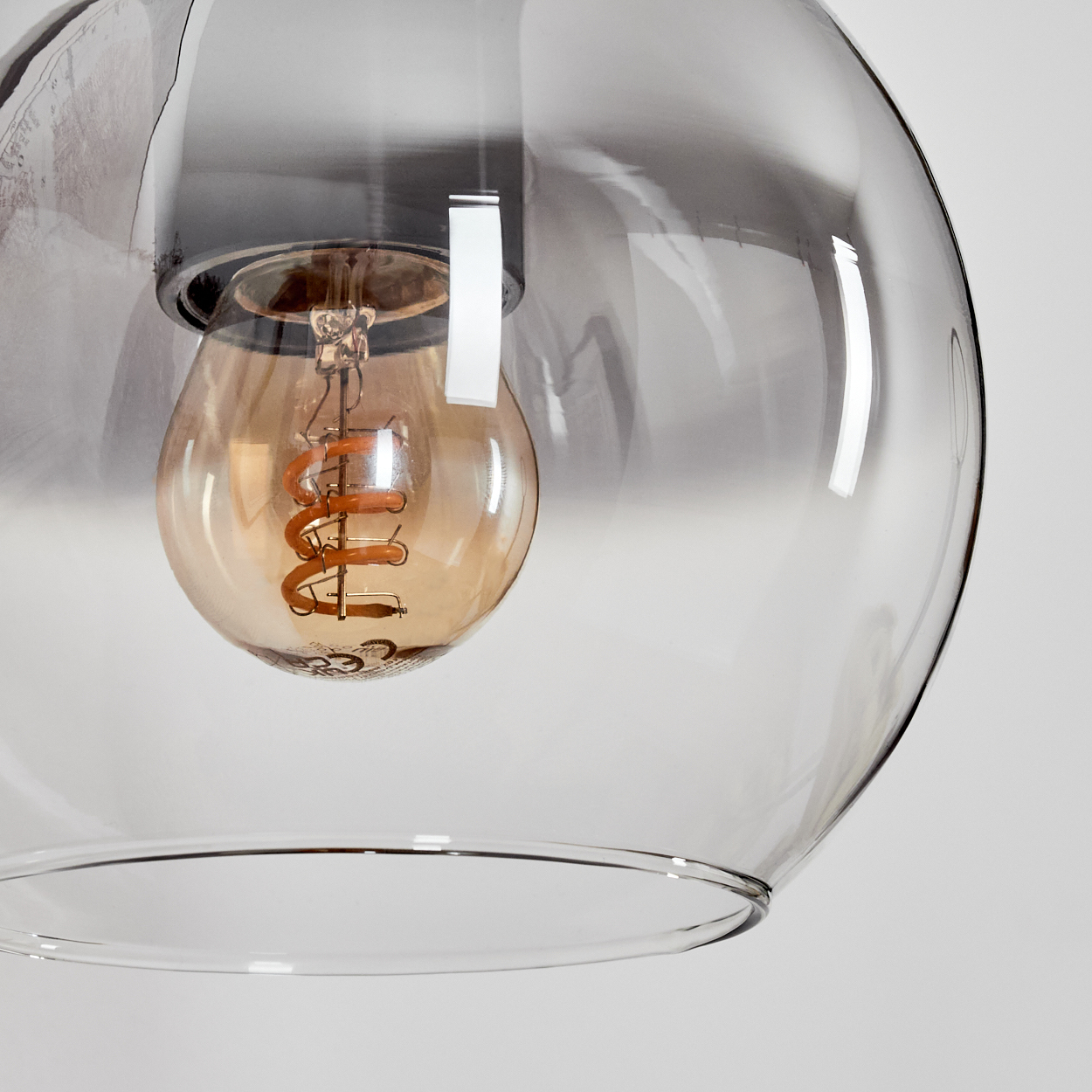 Eine Glühbirne mit Spiralwendel in einer transparenten Glasglocke.