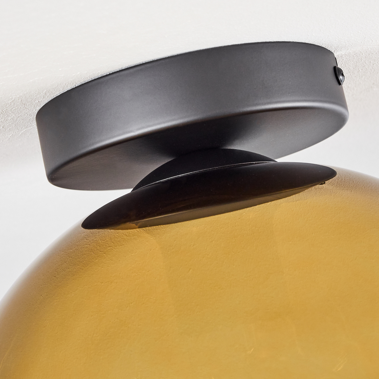 Deckenleuchte mit bernsteinfarbenem Glas und schwarzem Metall. Detailansicht.