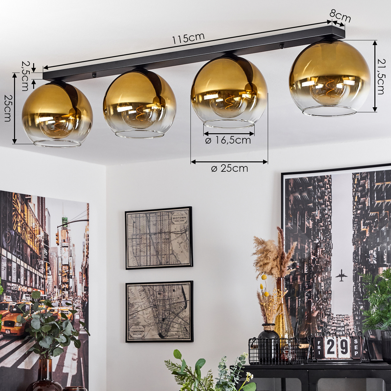 Eine Deckenleuchte mit vier goldenen Glaskugeln an einer schwarzen Stange.