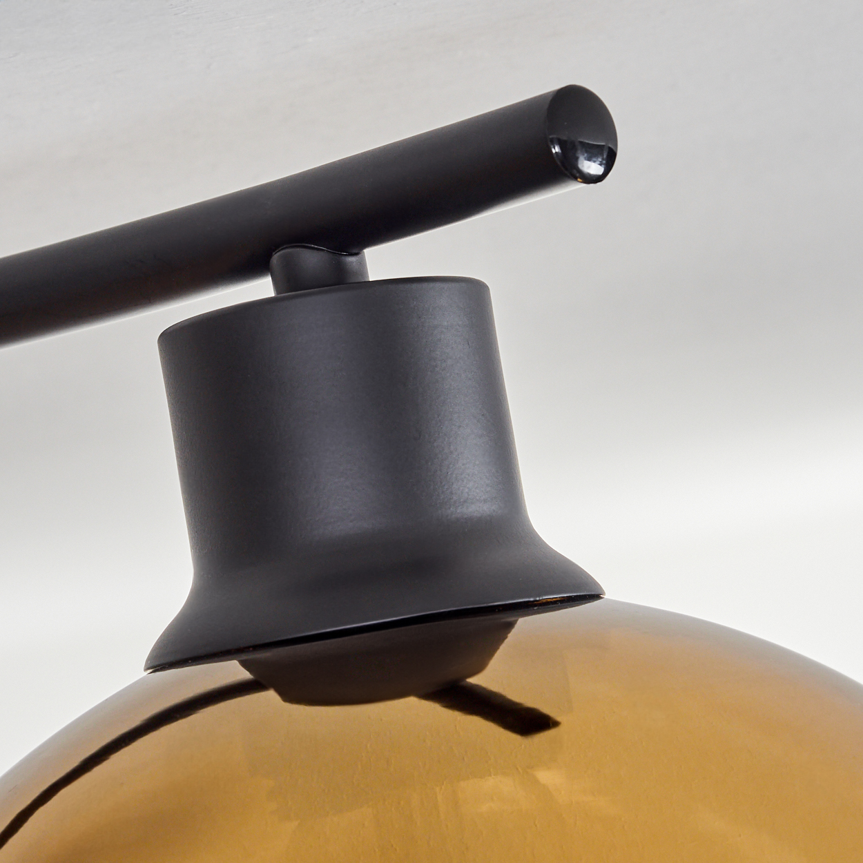 Nahaufnahme einer schwarzen Lampe mit bernsteinfarbenem Glas.