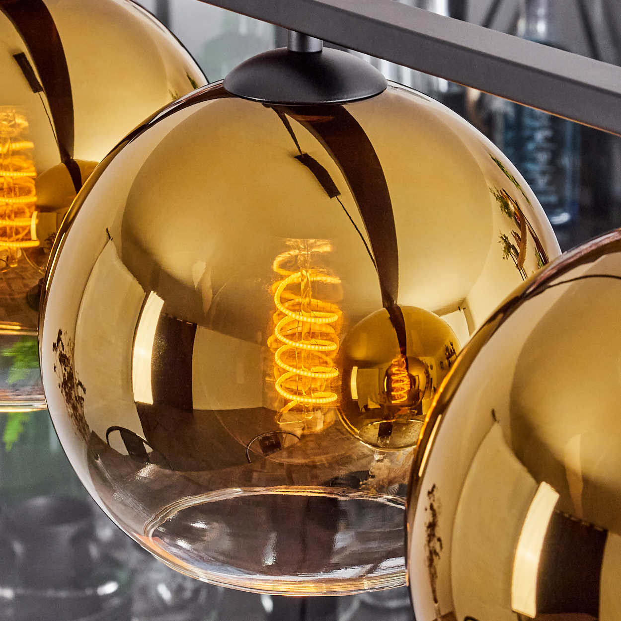 Moderne Lampe mit bernsteinfarbenen Glaskugeln und sichtbaren Glühfäden.
