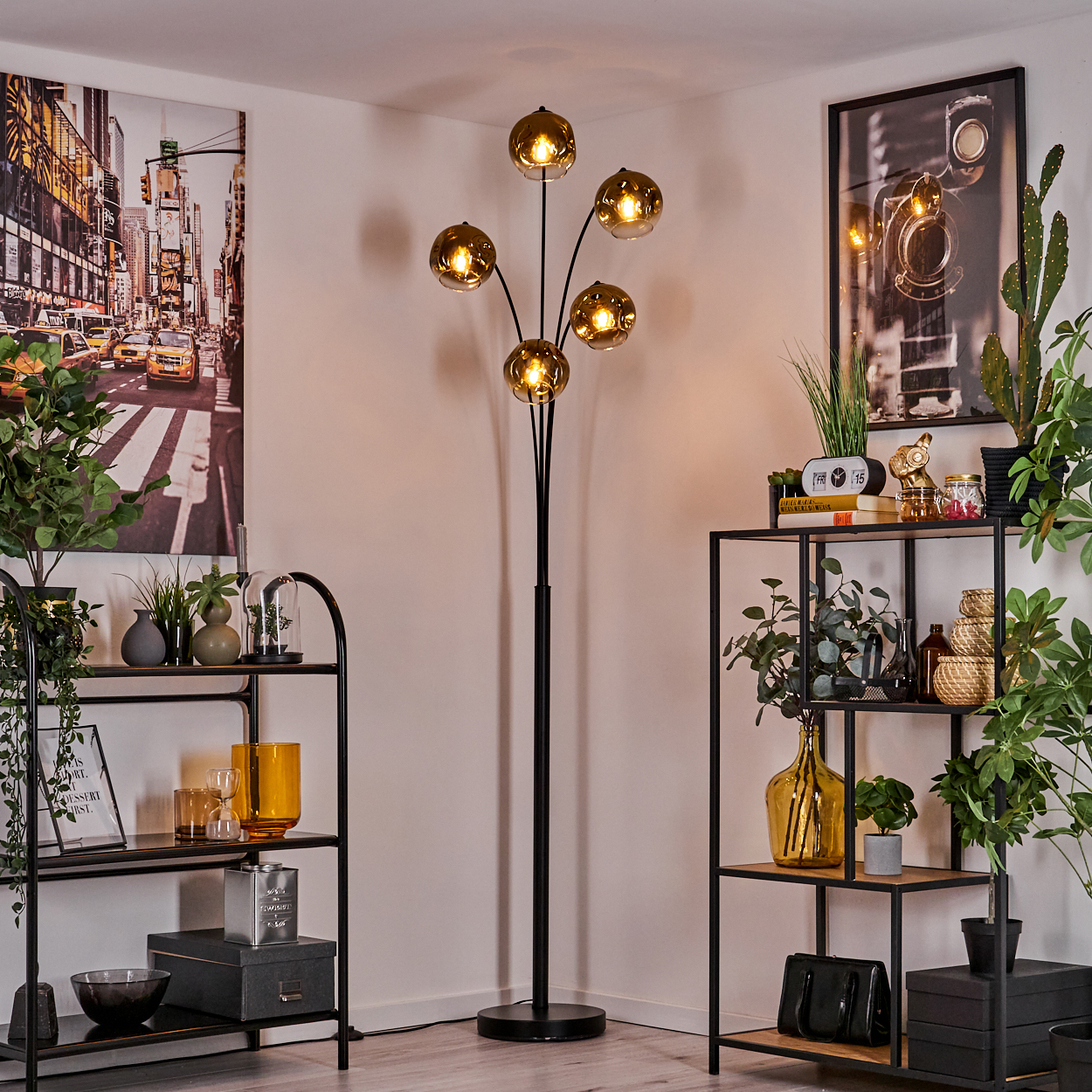 Ein Wohnzimmer mit einem Mehrarmleuchter, Regalen und Kunstwerken.