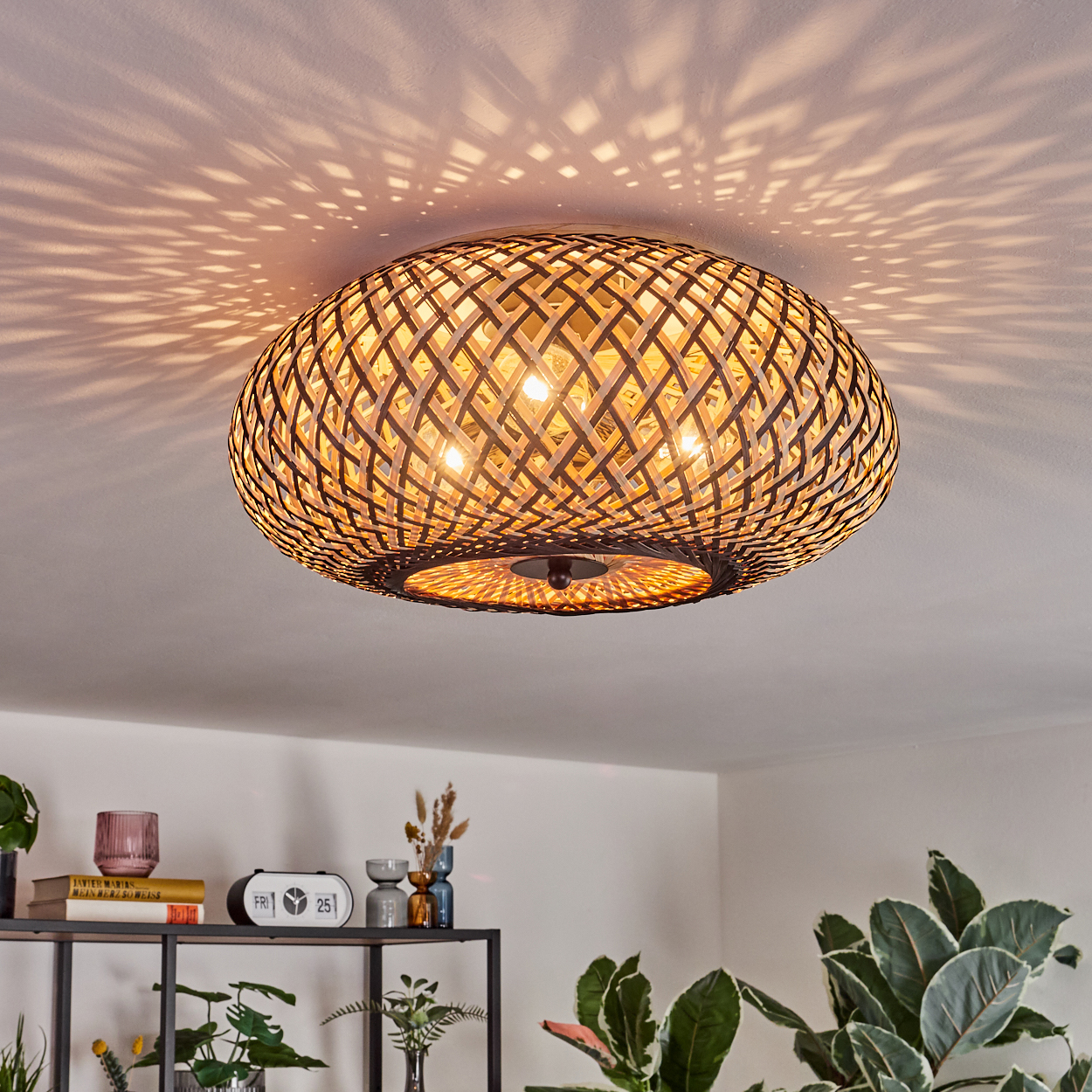 Eine runde, geflochtene Lampe wirft Muster an die Decke.