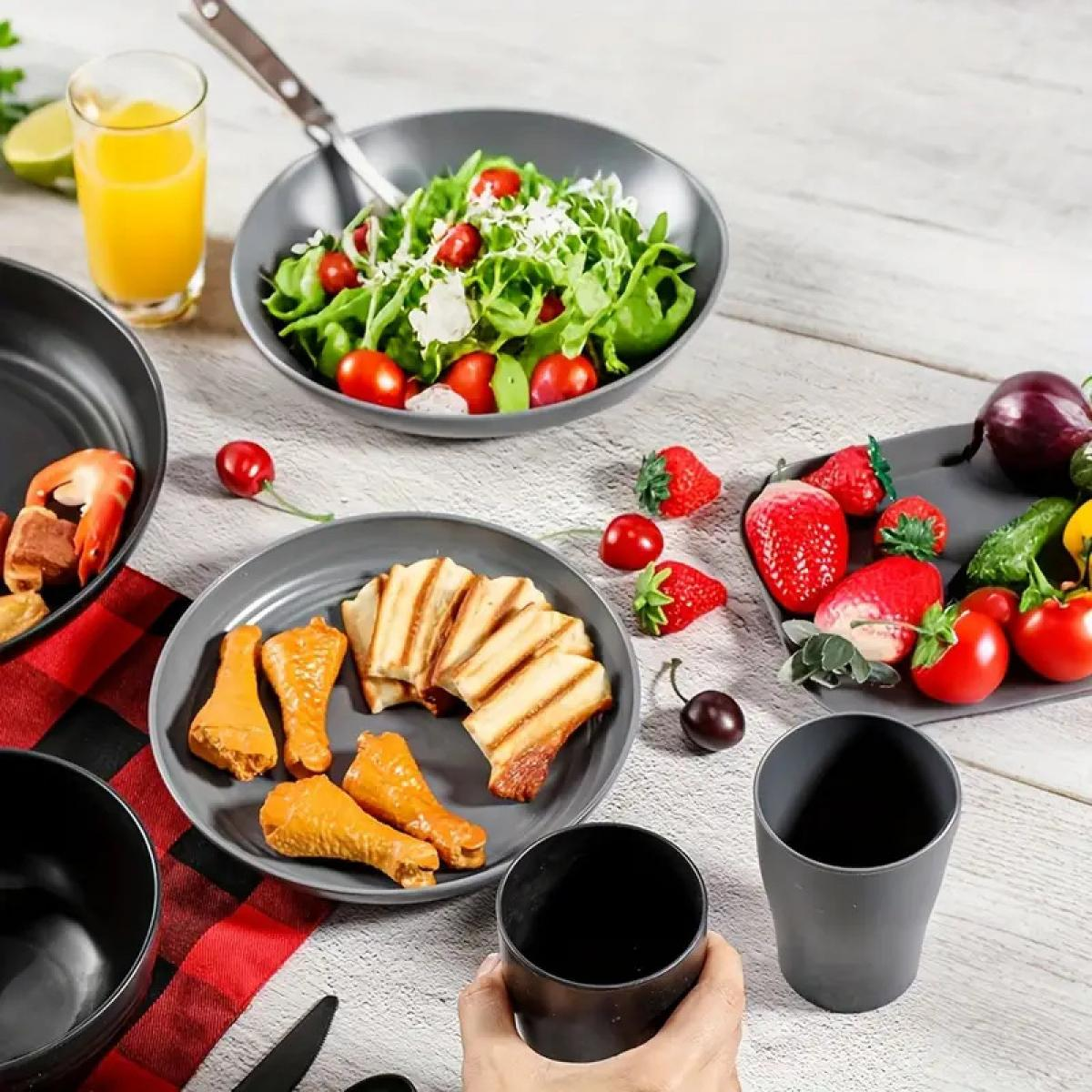 Tisch mit Essen: Salat, Hähnchenschenkel, Toast, Beeren und Getränke.