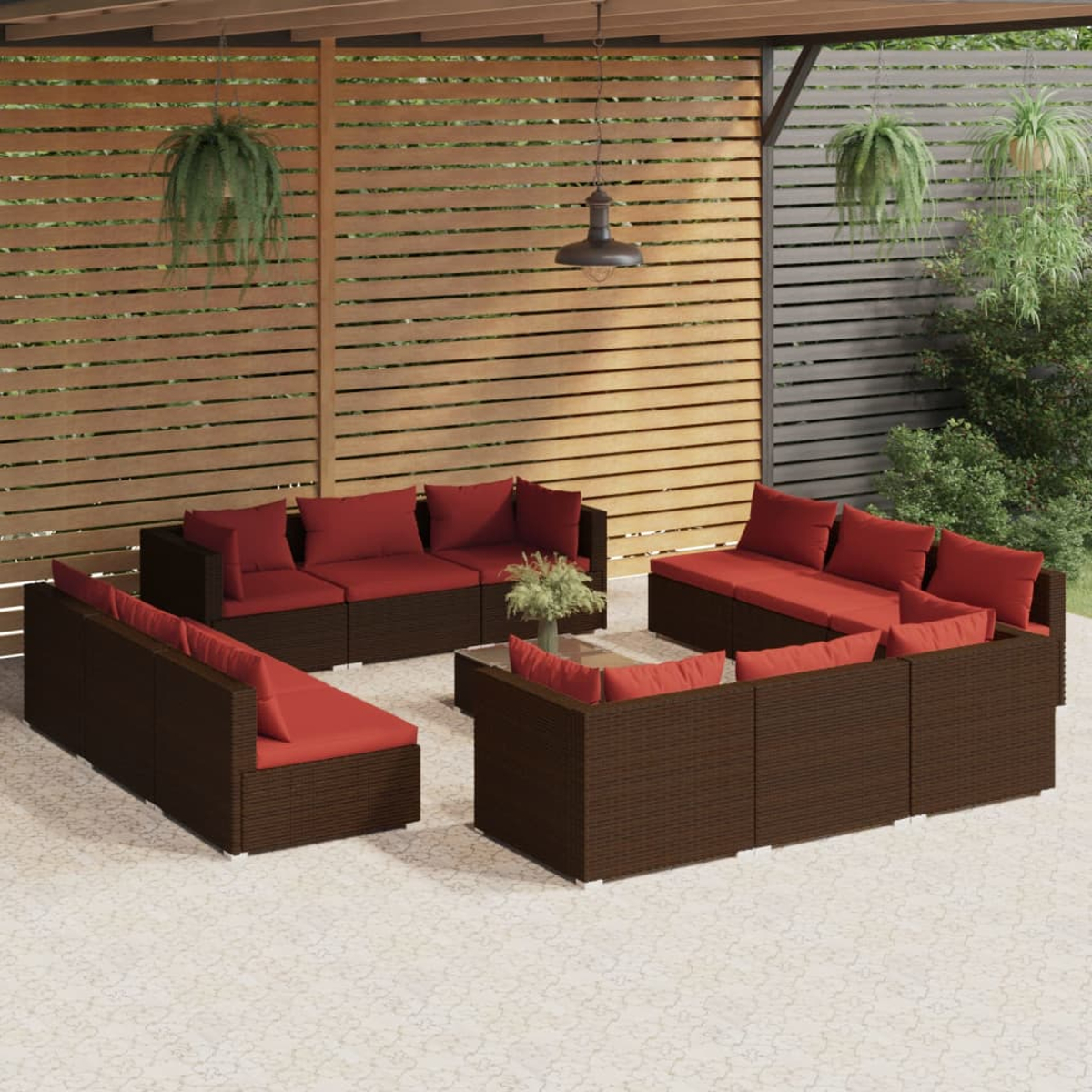 Mobili da giardino in rattan marrone con cuscini rossi sotto un pergolato in legno.