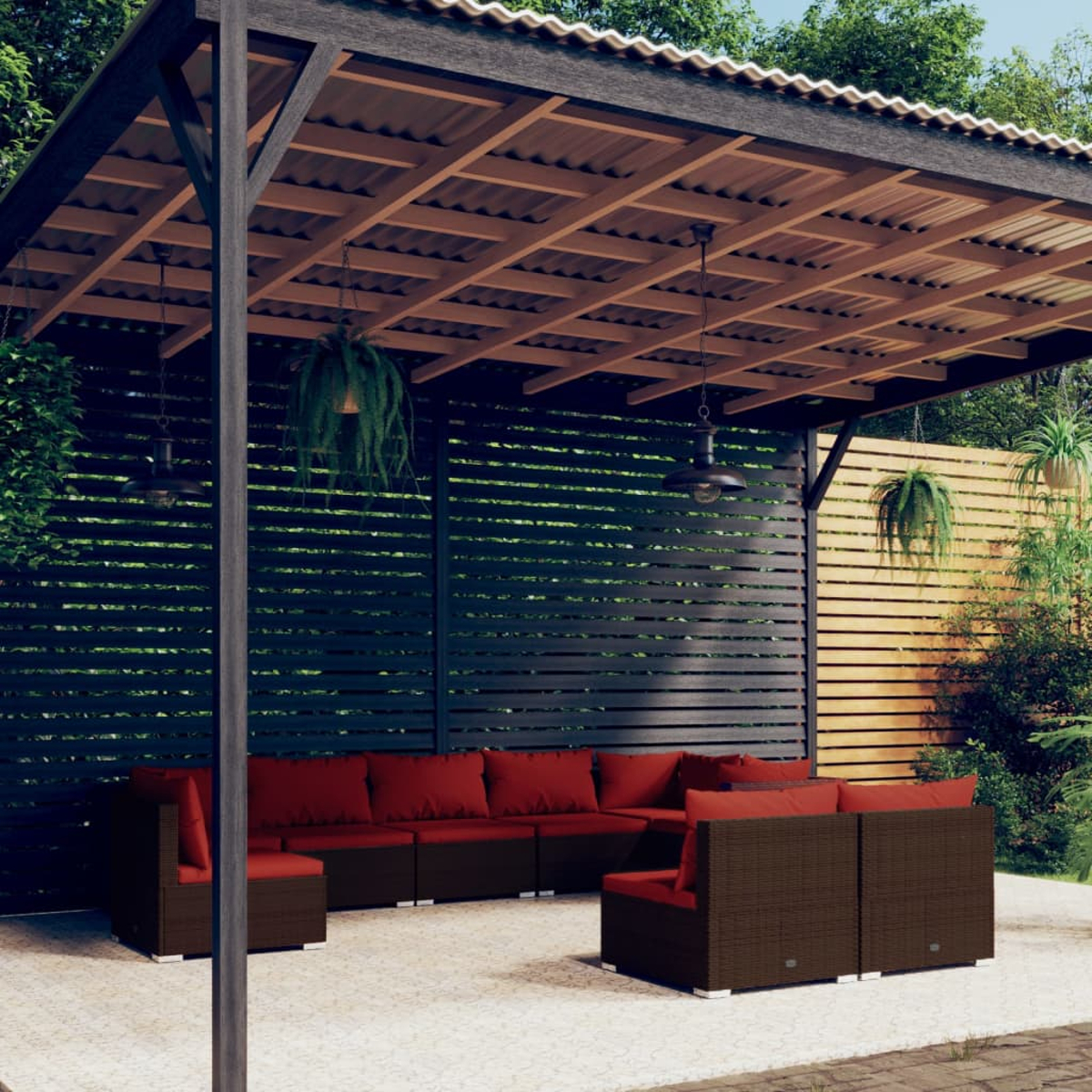 Area salotto esterna coperta con divani in rattan marrone e cuscini rossi.