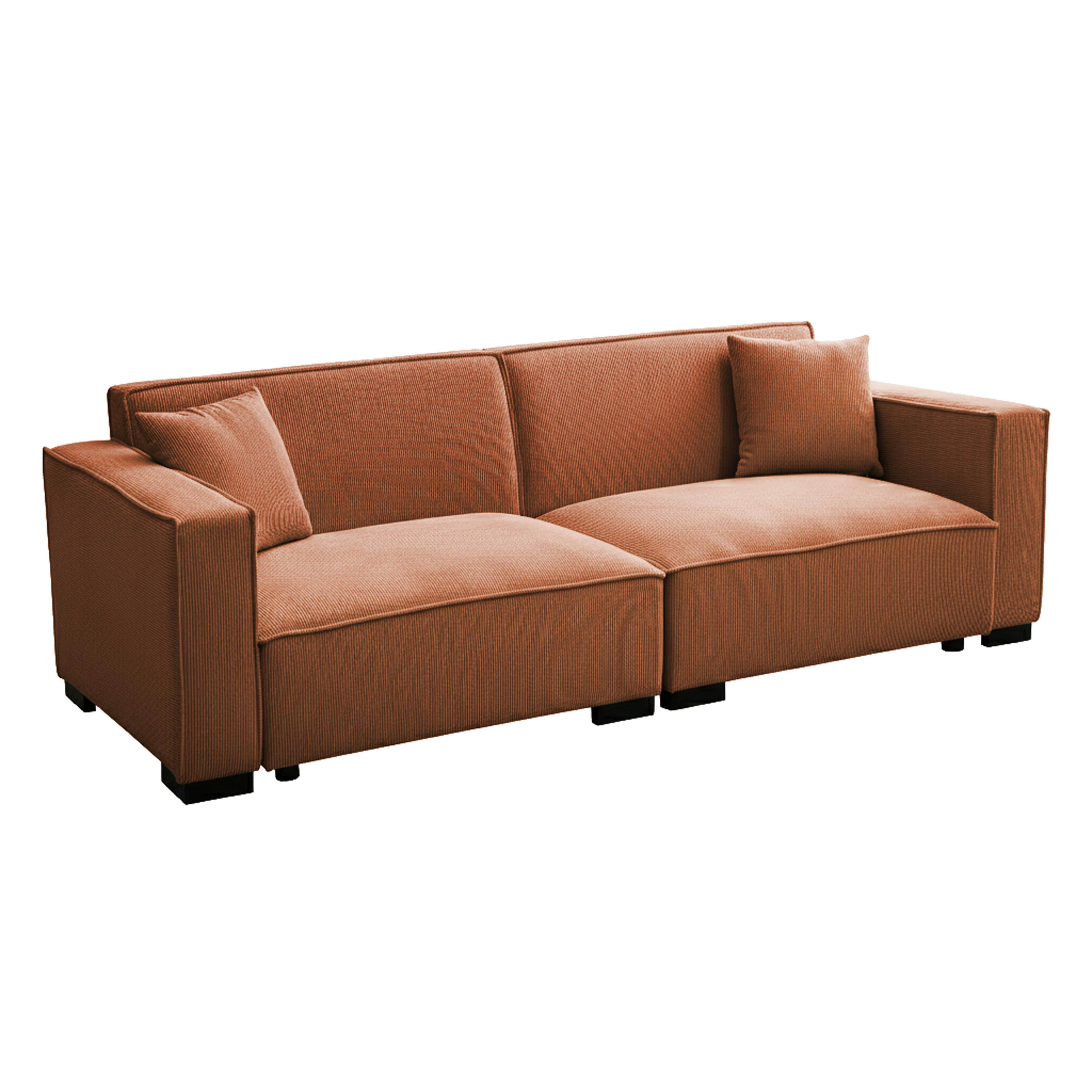 Ein korallenfarbenes Cord-Sofa mit zwei Hockern und zwei Kissen.