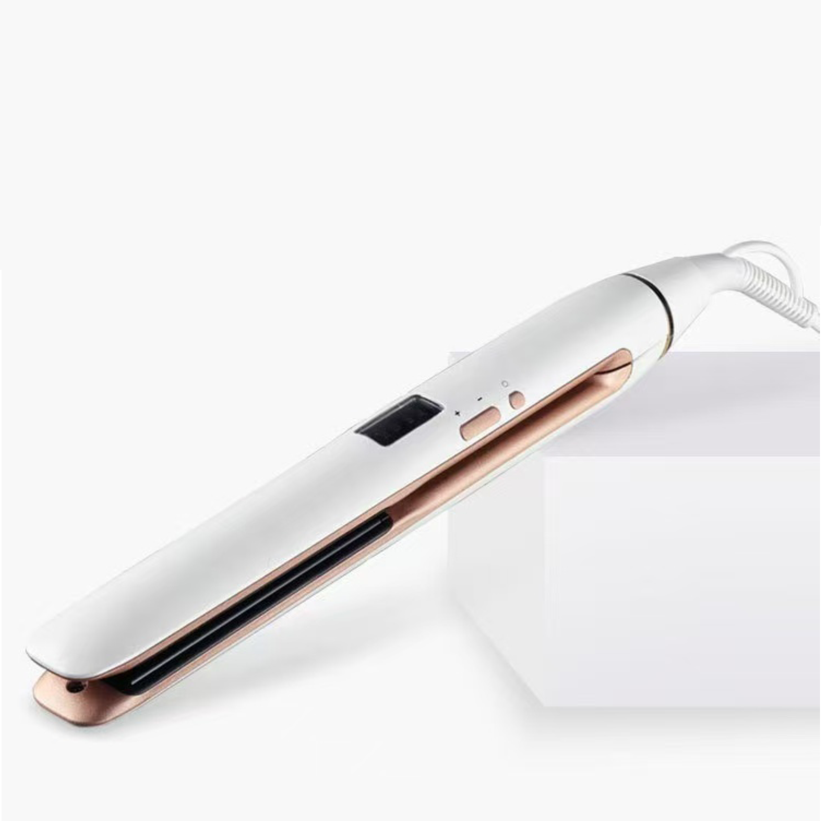 Una piastra per capelli bianca con accenti oro rosa poggia su un cubo bianco.
