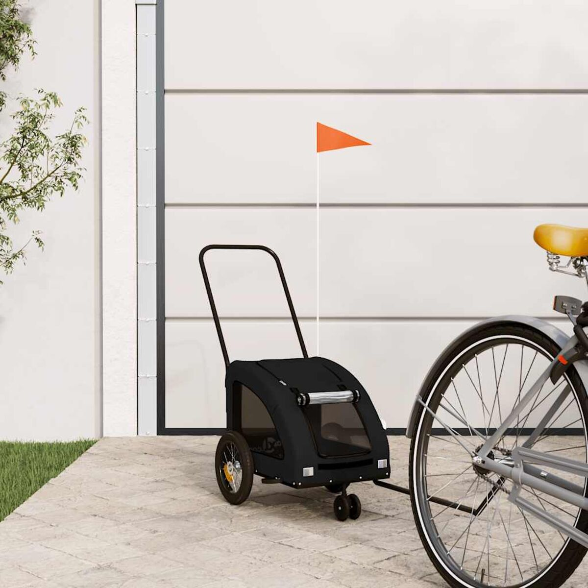Ein schwarzer Hundanhänger mit orangener Flagge steht neben einem Fahrrad.