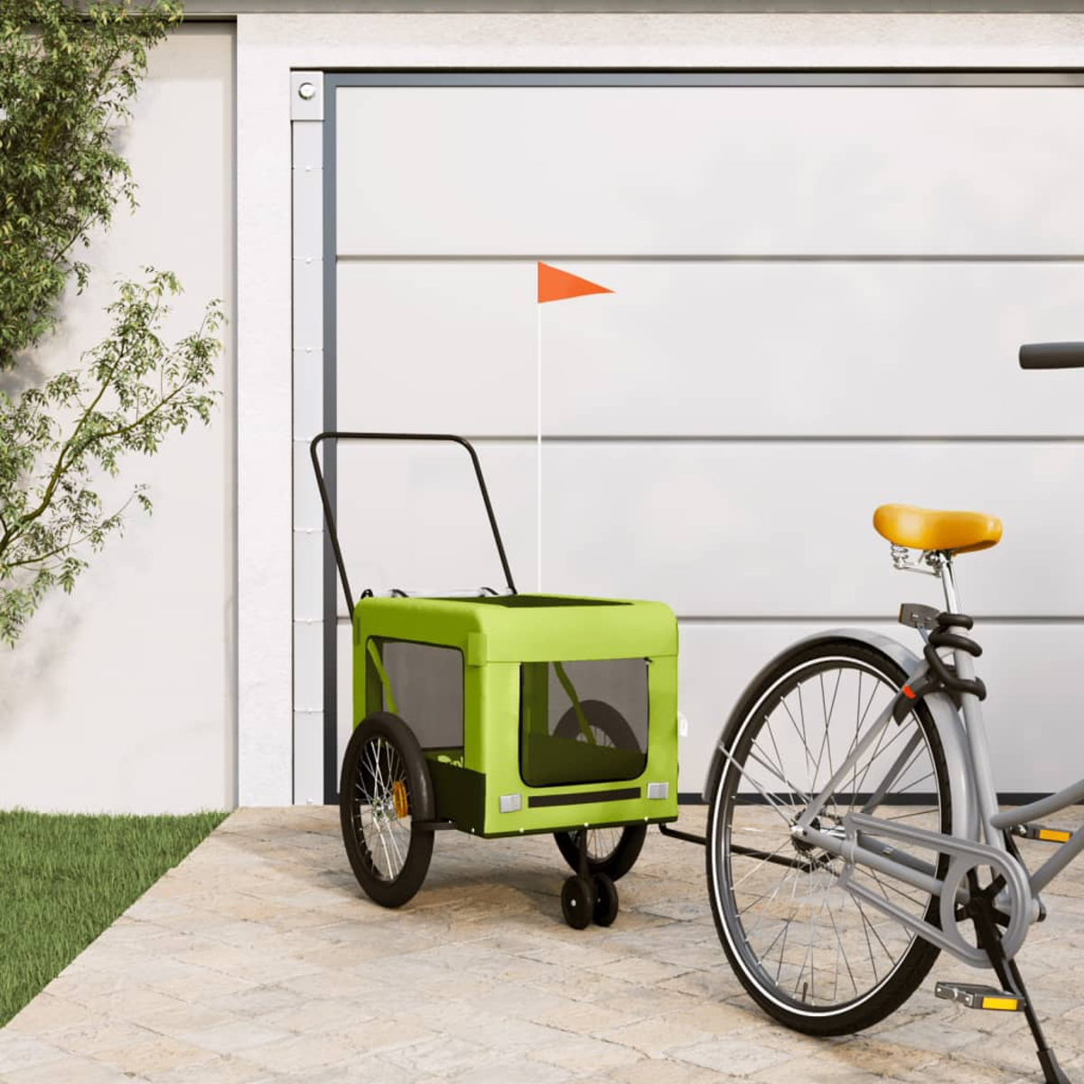 Ein grüner Fahrradanhänger steht neben einem Fahrrad vor einem Garagentor.