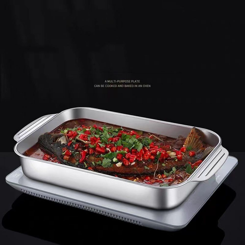 Ein ganzer Fisch, bedeckt mit Chilis und Kräutern, in einer Metallschale.