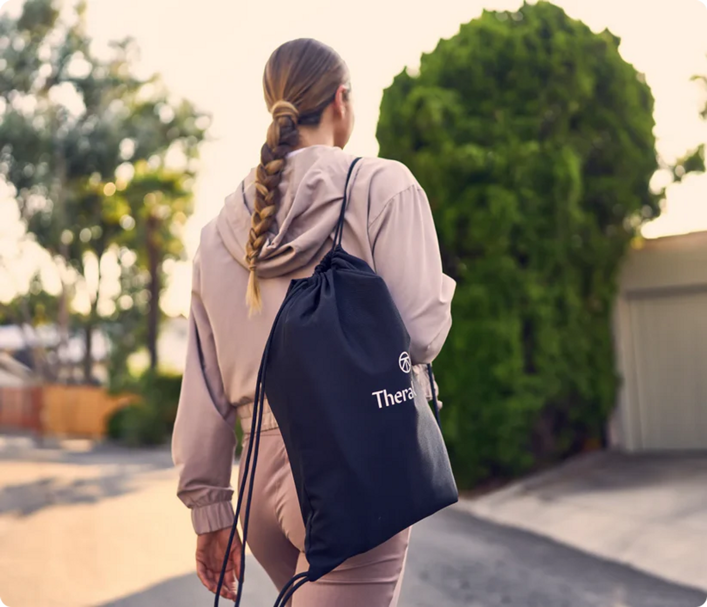Donna con treccia e borsa nera cammina verso destra.
