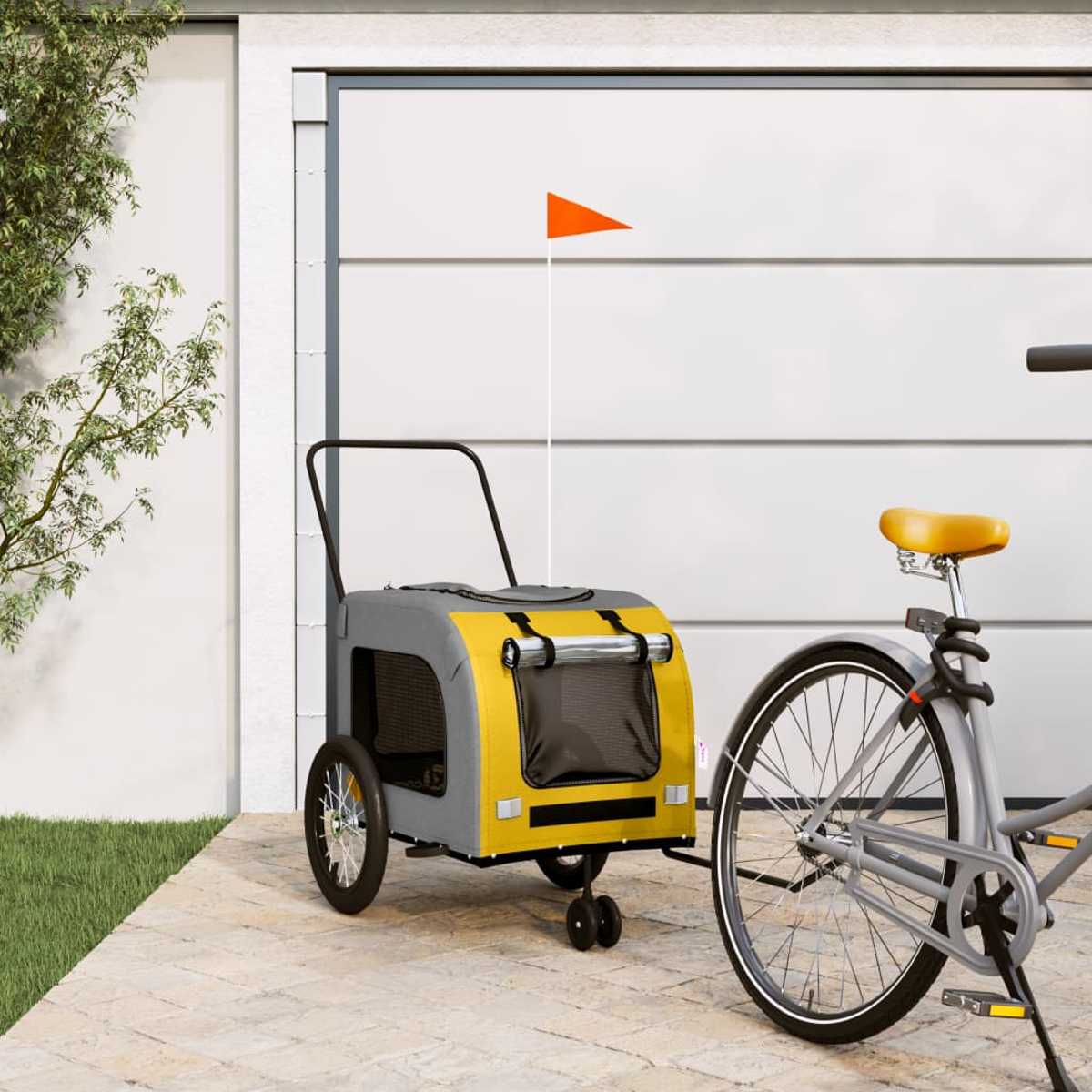 Ein Fahrradanhänger mit orangefarbener Fahne steht neben einem Fahrrad.