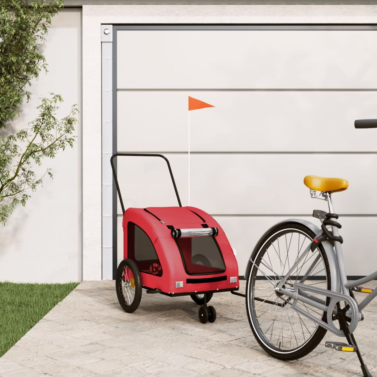 Ein roter Fahrradanhänger mit orangem Fähnchen neben einem grauen Fahrrad.