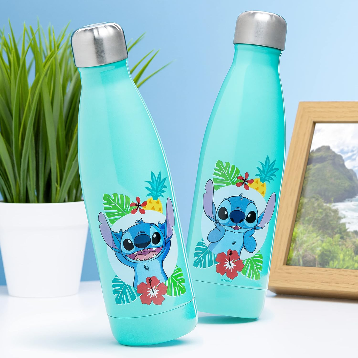 Zwei türkise Wasserflaschen mit Stitch-Motiven vor blauem Hintergrund.