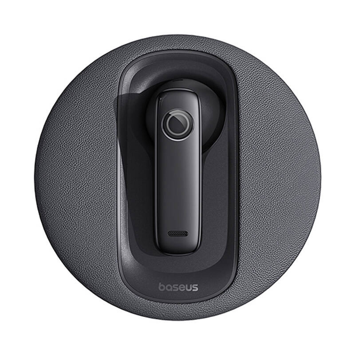Un auricolare Bluetooth nero nella sua custodia di ricarica su una base circolare grigia.