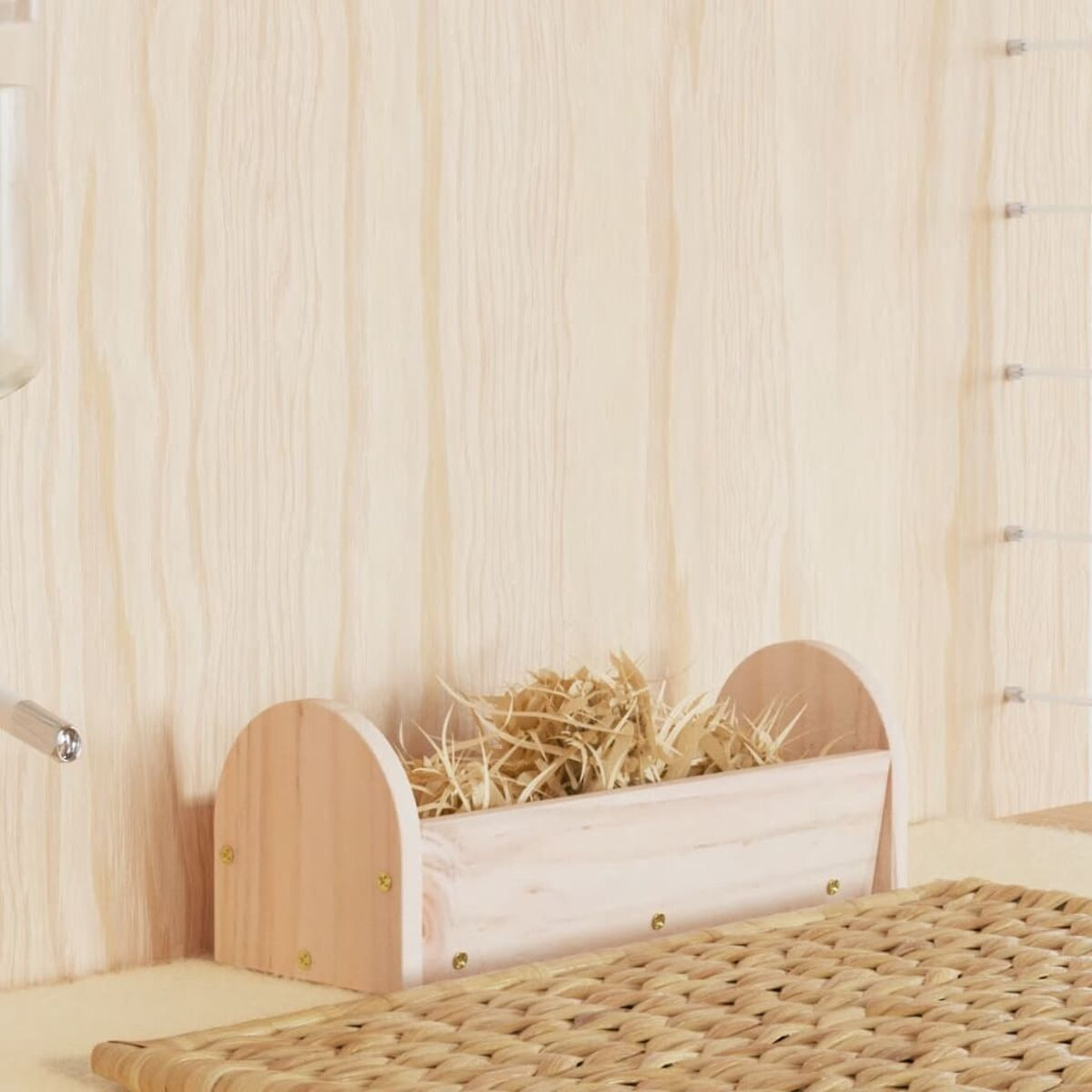 Una mangiatoia in legno riempita di fieno davanti a un muro di legno.