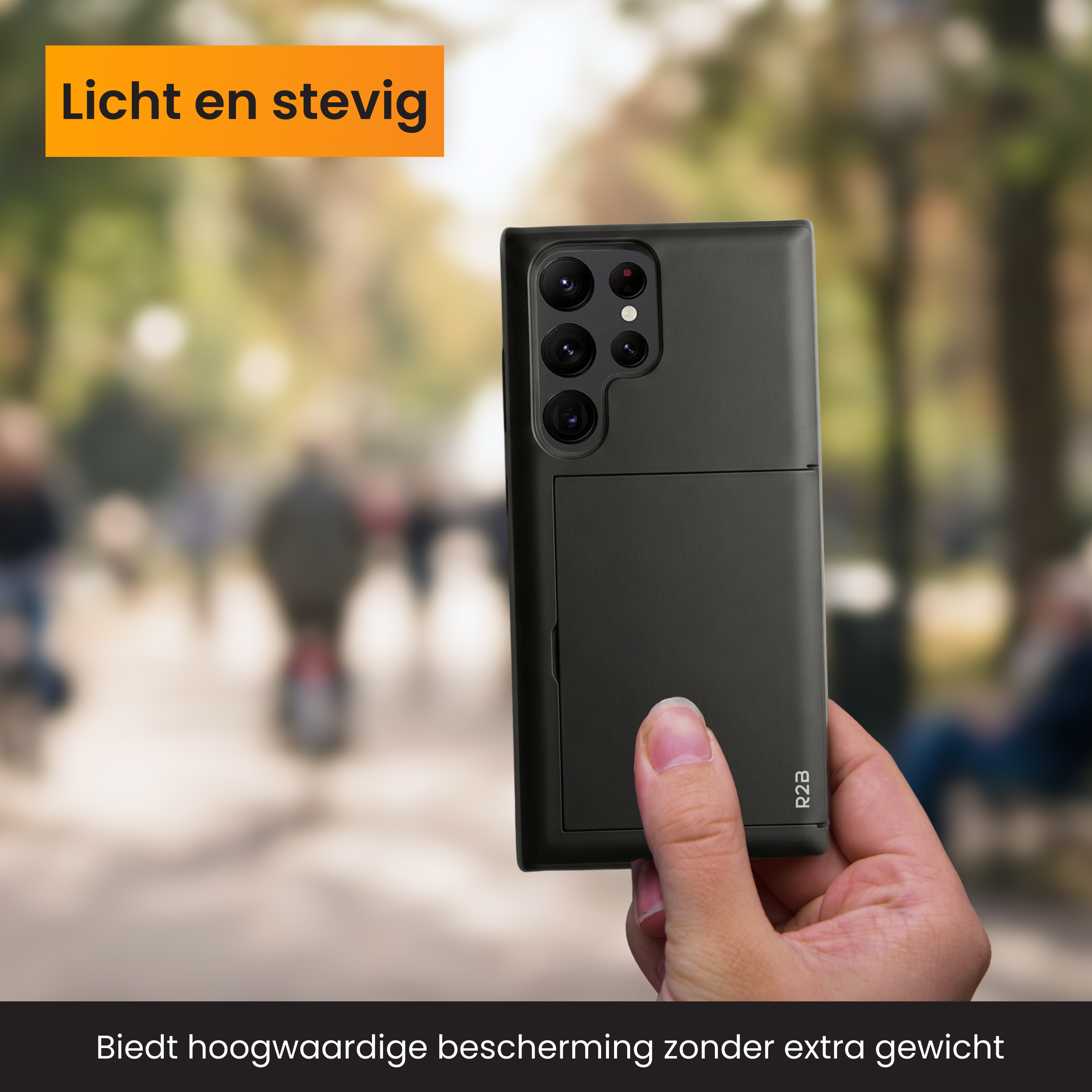 Une main tient un étui de téléphone noir avec des objectifs d'appareil photo. Dehors.