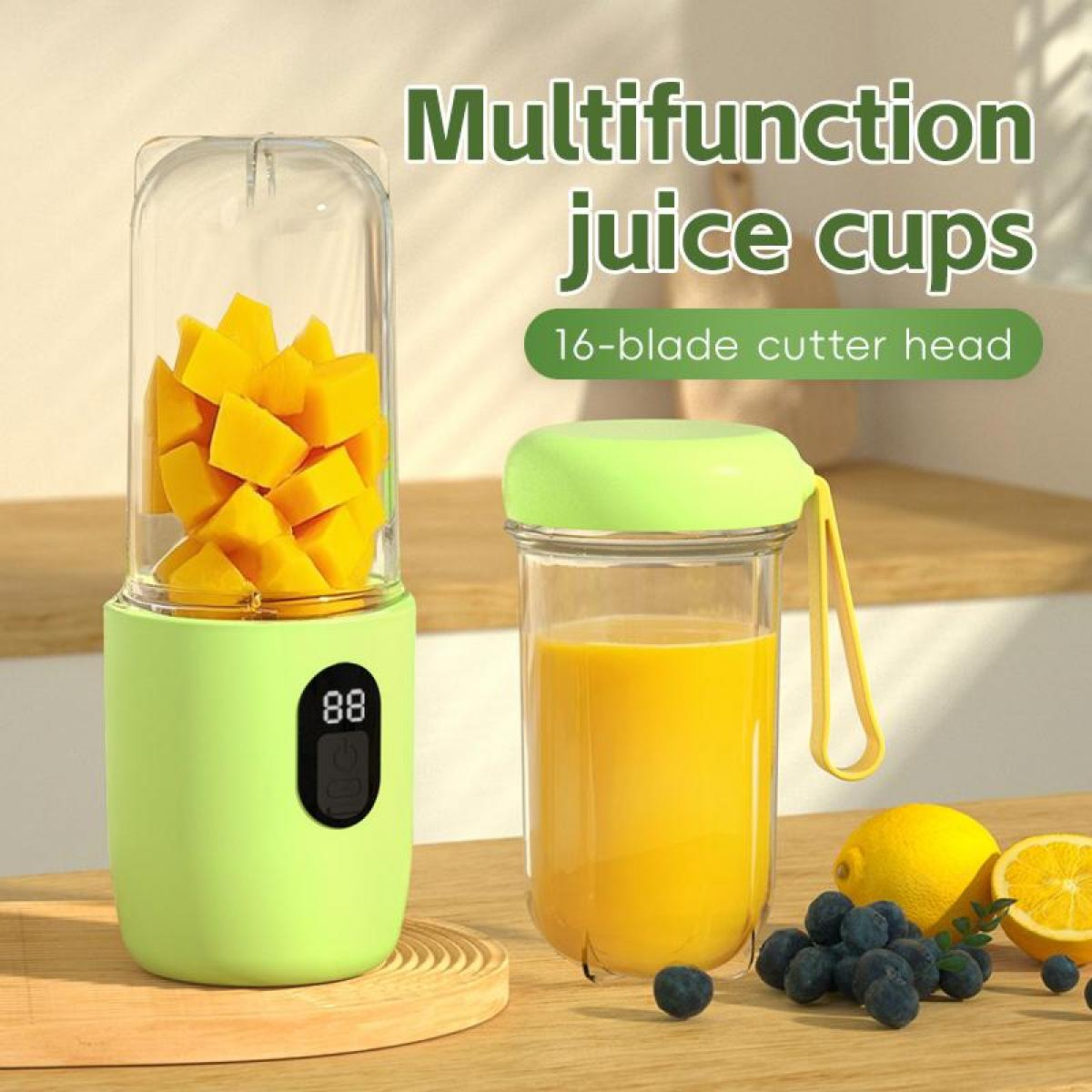 Ein grüner Mixer mit Mangostücken und ein Glas Saft daneben. Früchte liegen davor.